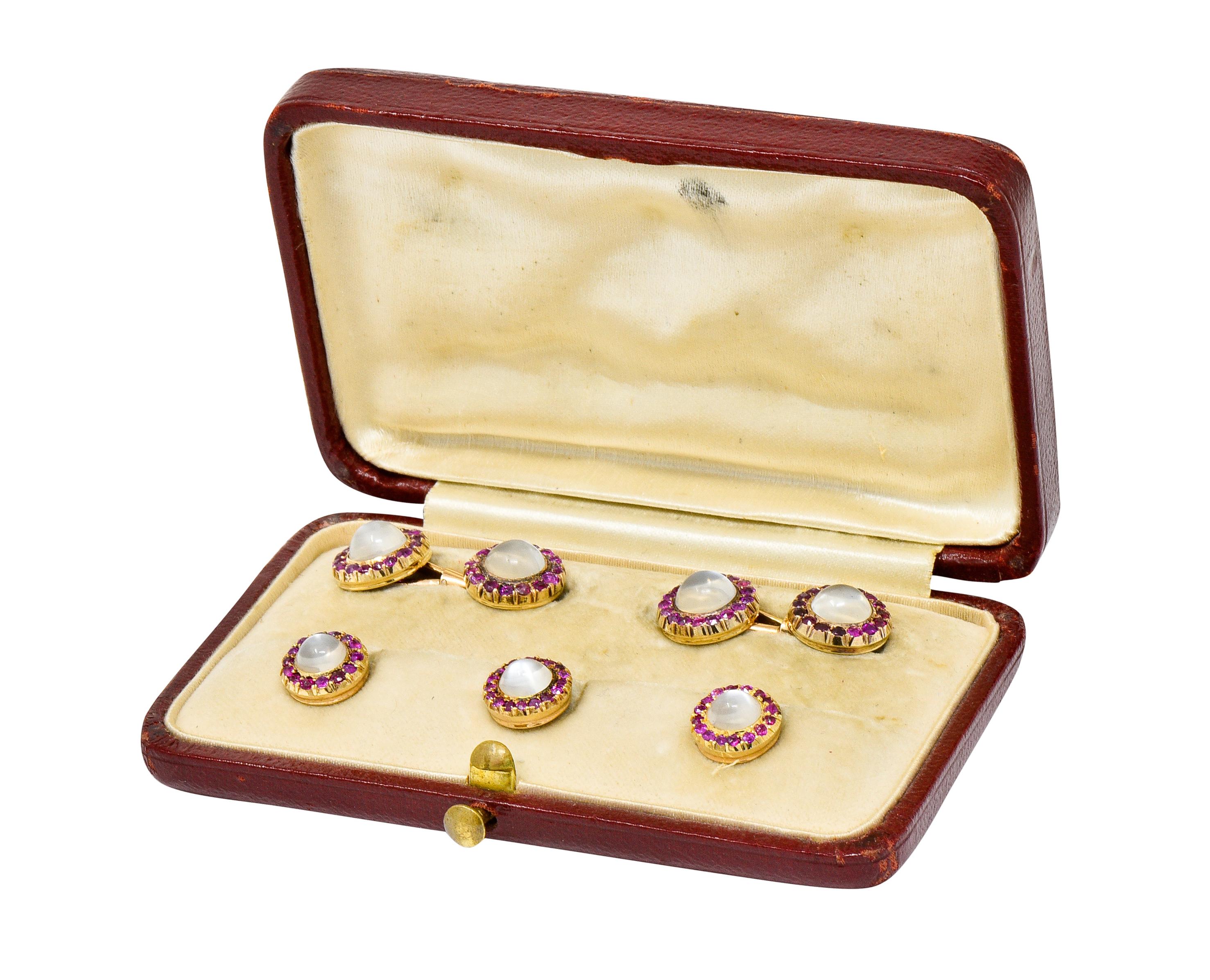 Link style cufflinks with both ends centering a round moonstone cabochon measuring approximately 7.0 mm

Surrounded by a halo of round cut rubies, red to purplish-red in color

With three matching lever style shirt studs centering a moonstone