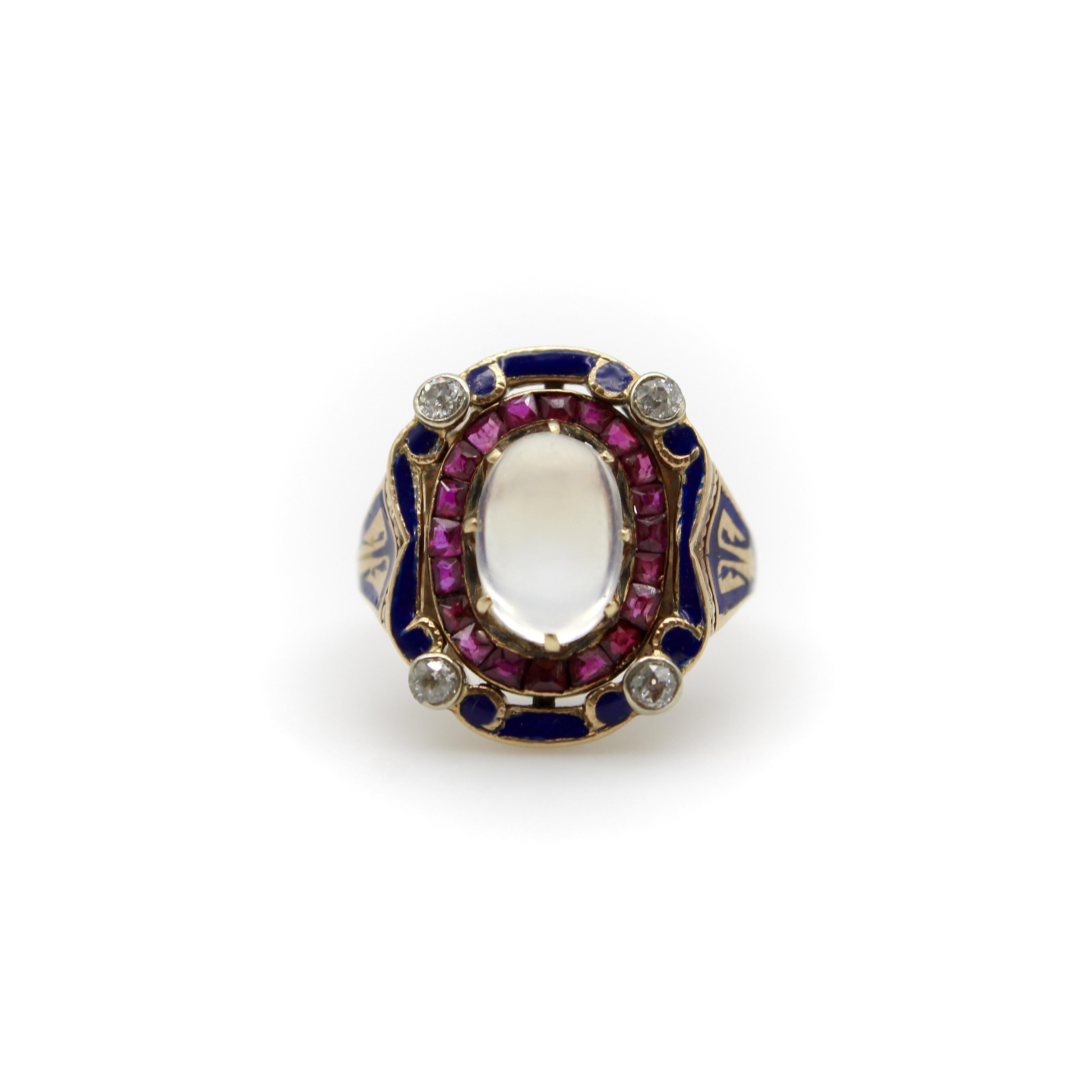 Questo anello vittoriano è come una torta a strati, con pietra di luna, diamanti, rubini e uno splendido smalto blu cobalto. Il centro dell'anello è un grande cabochon di pietra di luna con una cupola alta. La pietra di luna ha una colata blu e una