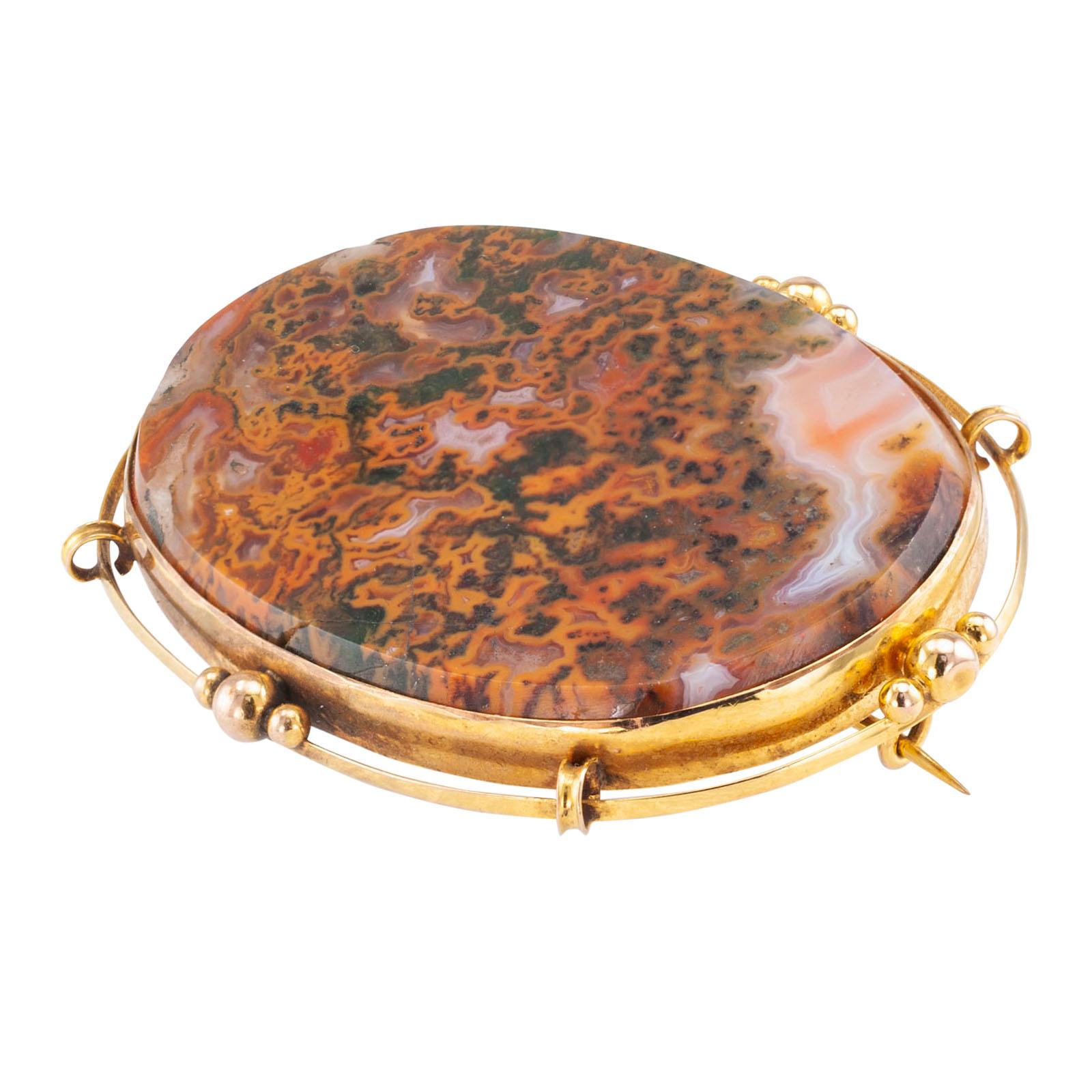 Victorian moss agate and yellow gold brooch circa 1900.

DETAILS:
GEMSTONES: one large oval flat-top moss agate stone.

METAL: 9-karat yellow gold.

MEASUREMENTS: approximately 2-5/16” (5.9 cm) horizontal width and 1-3/4” (4.4 cm) vertical