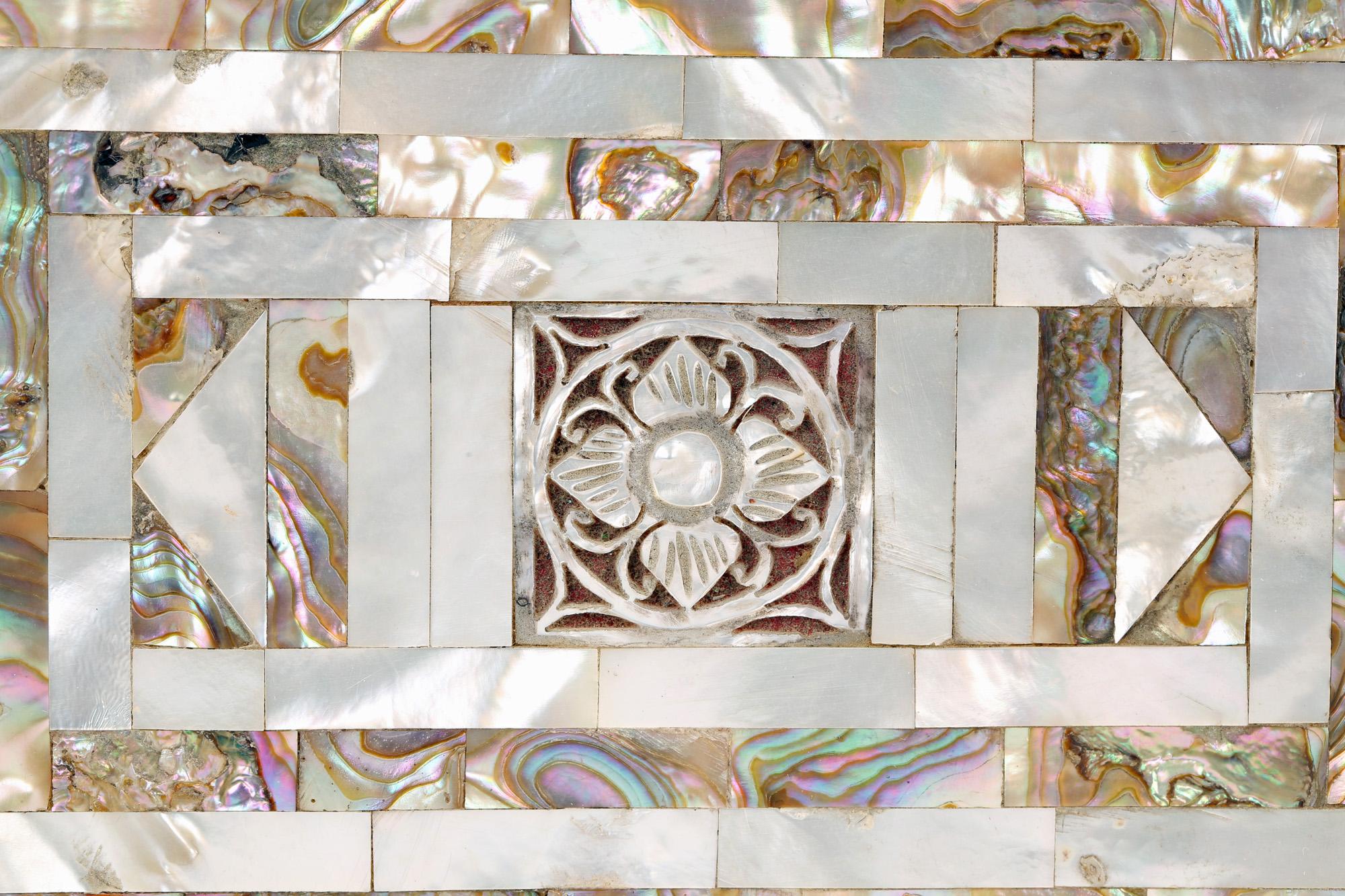 A stunning antique Victorian mother of pearl inlaid jewelry box dating from the 19th century. The box is of rectangular form with the wooden carcass mounted with mother of pearl in varying shapes and in contrasting colors with panels with a cross