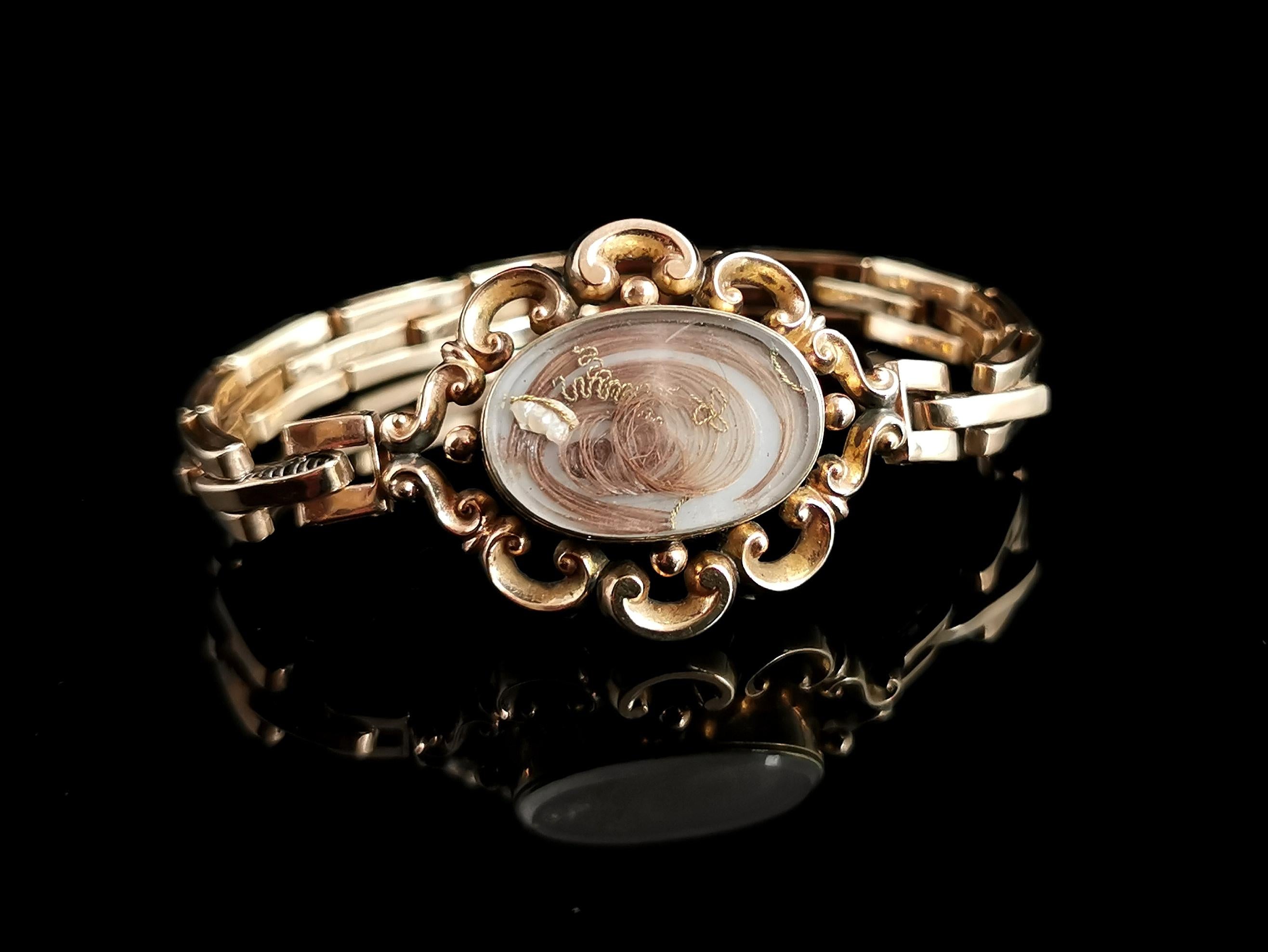 A beautiful antique gold mourning bracelet.

This bracelet features an early Victorian central mourning panel in scrolling 9c karat yellow gold with glazed compartments on both sides, each side has a fine hairwork spray secured with gold thread and
