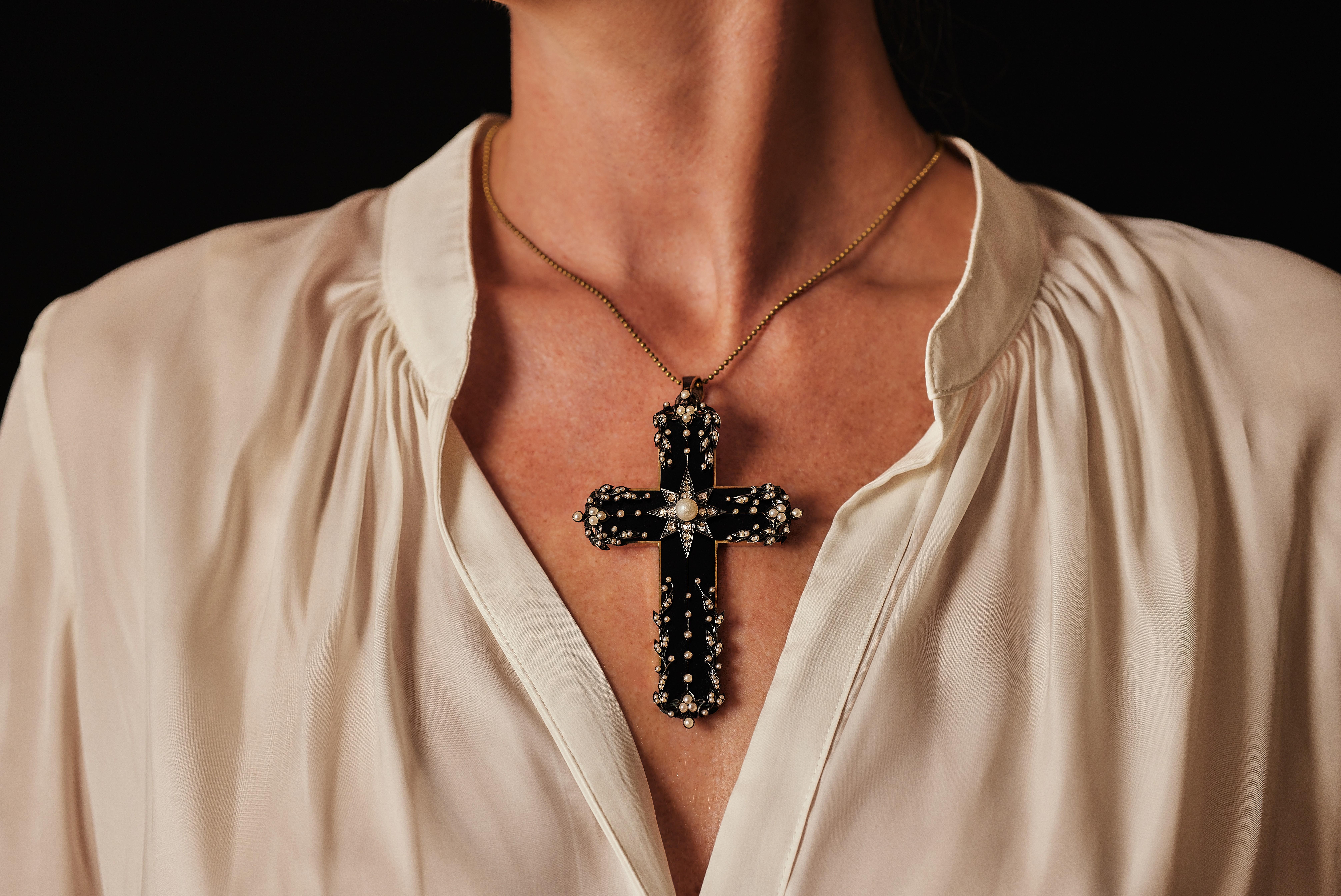 A big antique Victorian mourning cross. Ornately decorated with small river pearls around a silver star set with rose-cut diamonds centering a pearl. On the back is a small relics compartment. 

Weight approx. 33.6 grams.
Tested for 14k gold.