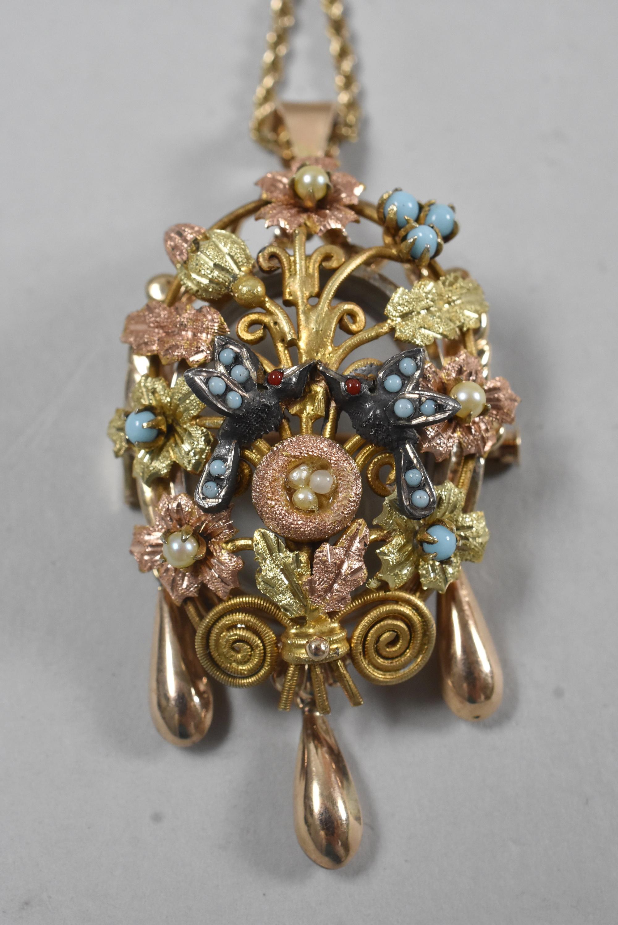 Victorian three colored gold mourning pendant. Floral sprays with inset pearls and turquoise. Pair of birds in the center above a nest holding pearl eggs. Three bottom tear drop dangles. Back is hinged with a glass cover. Rope 14-karat chain added