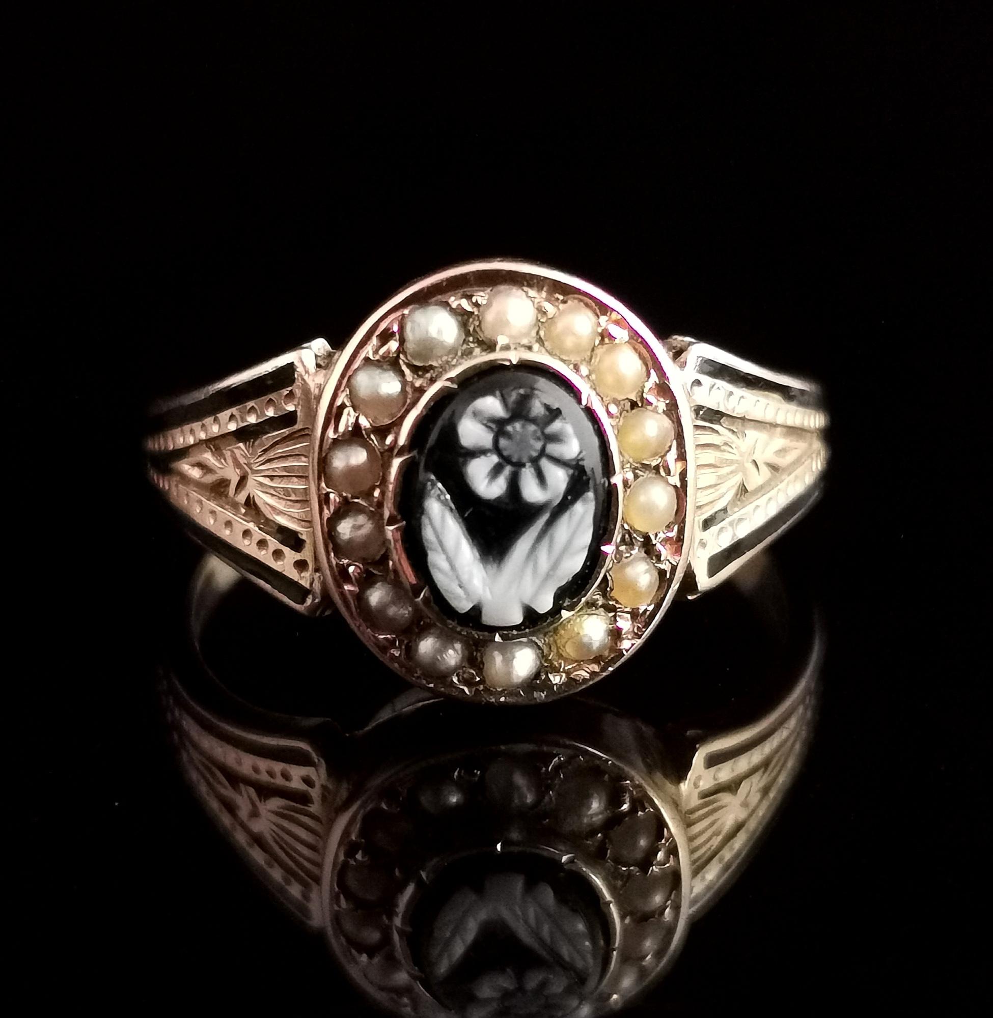 A stunning antique Victorian mourning ring.

If you are looking for a mourning ring that is filled with sentiment and symbolism then this is the one for you.

A rich 15 karat yellow gold engraved band with black enamel highlights, the centre has an