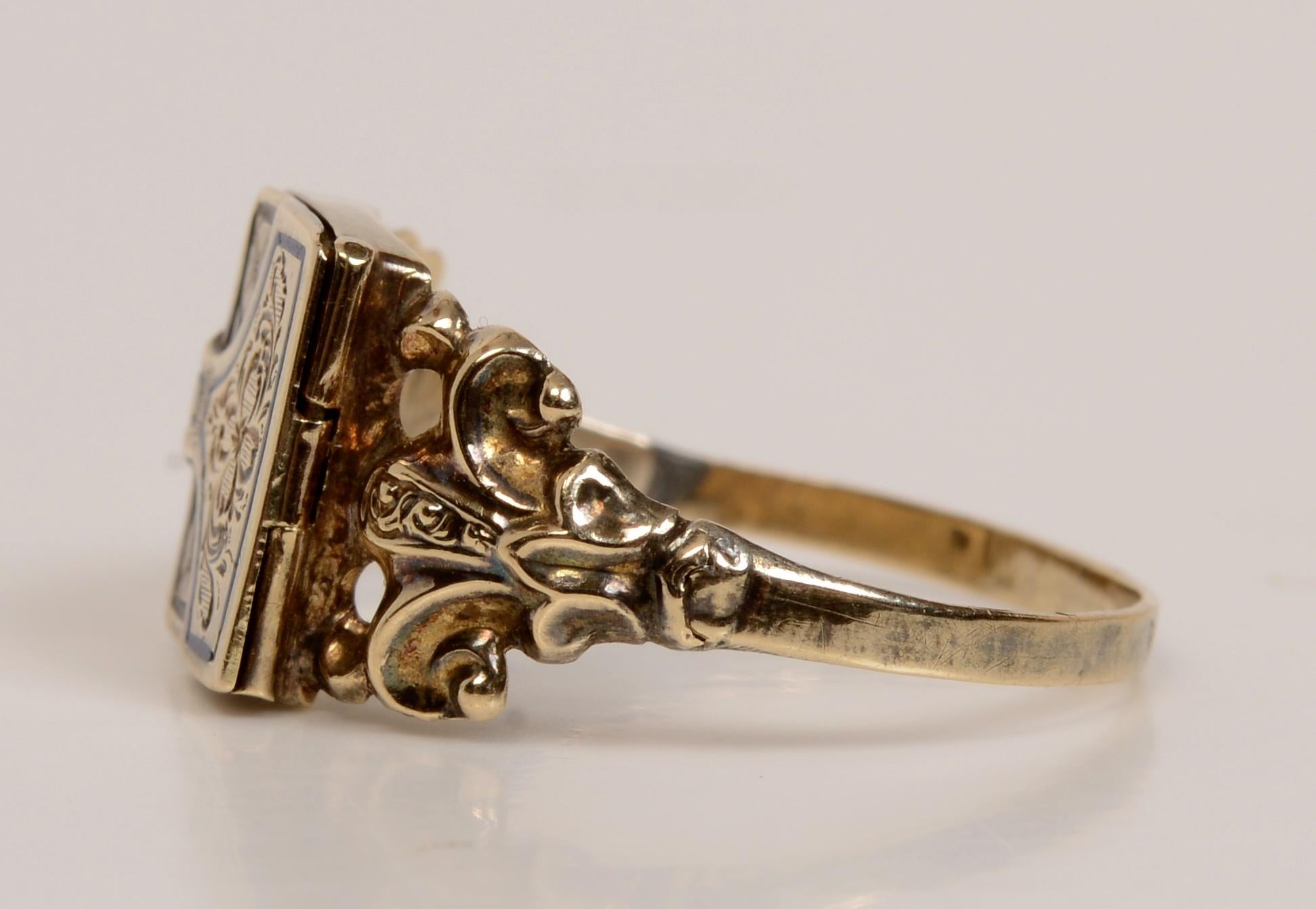 Viktorianische Trauer Ring c1840 mit aufklappbaren Buch Form Medaillon Front. Mit floral und blattgeschnitztem Gesicht und einer zentralen Reserve für eine Haarlocke. Die Tür hat ein feines blau emailliertes Dekor und wird von erhöhten Fleur de