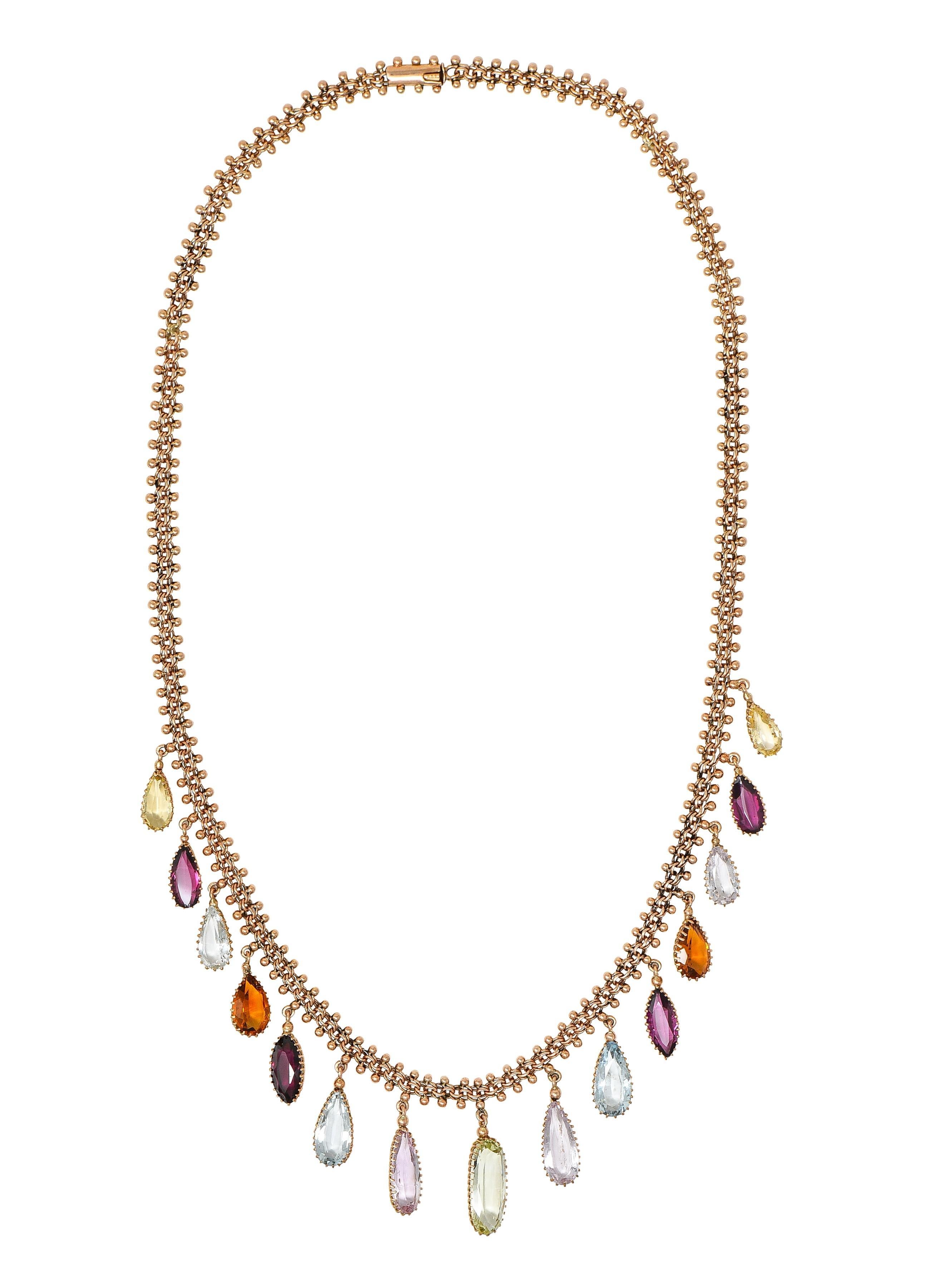 Designed as a fancy mesh chain with gold beading centering graduated multi-gem fringe station
Comprised of tourmaline, citrine, topaz, and aquamarine ranging in size and cut 
Transparent brownish orange, medium pink, light pink, green, and blue in