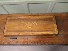 Caja de música victoriana Una caja de música cilíndrica con un diseño musical de marquetería