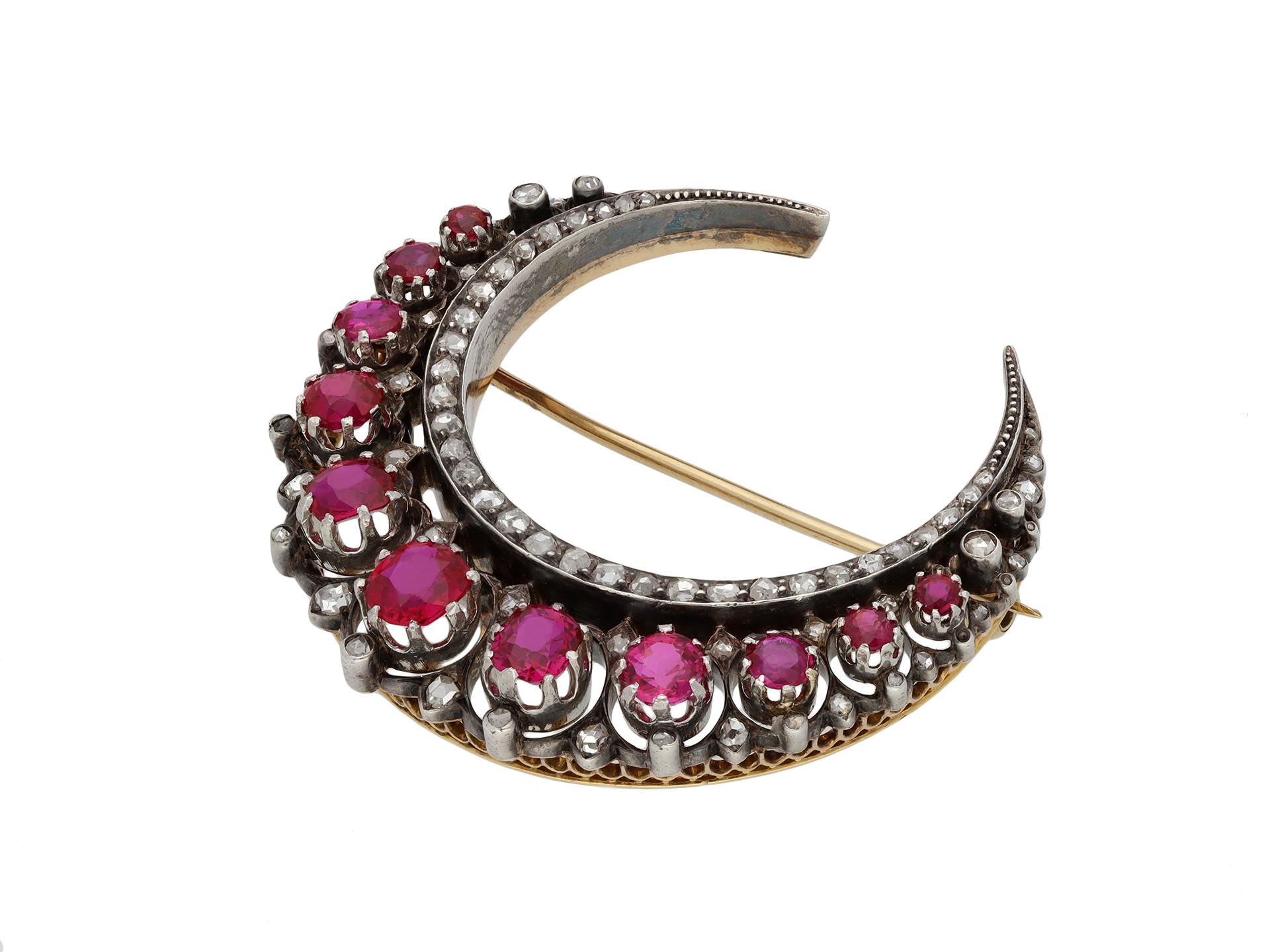 Victorian Burmese ruby and diamond crescent brooch. Set with eleven cushion shape old cut natural unenhanced Burmese rubies in open back claw settings with a combined approximate weight of 5.80 carats, further set with seventy five graduated round