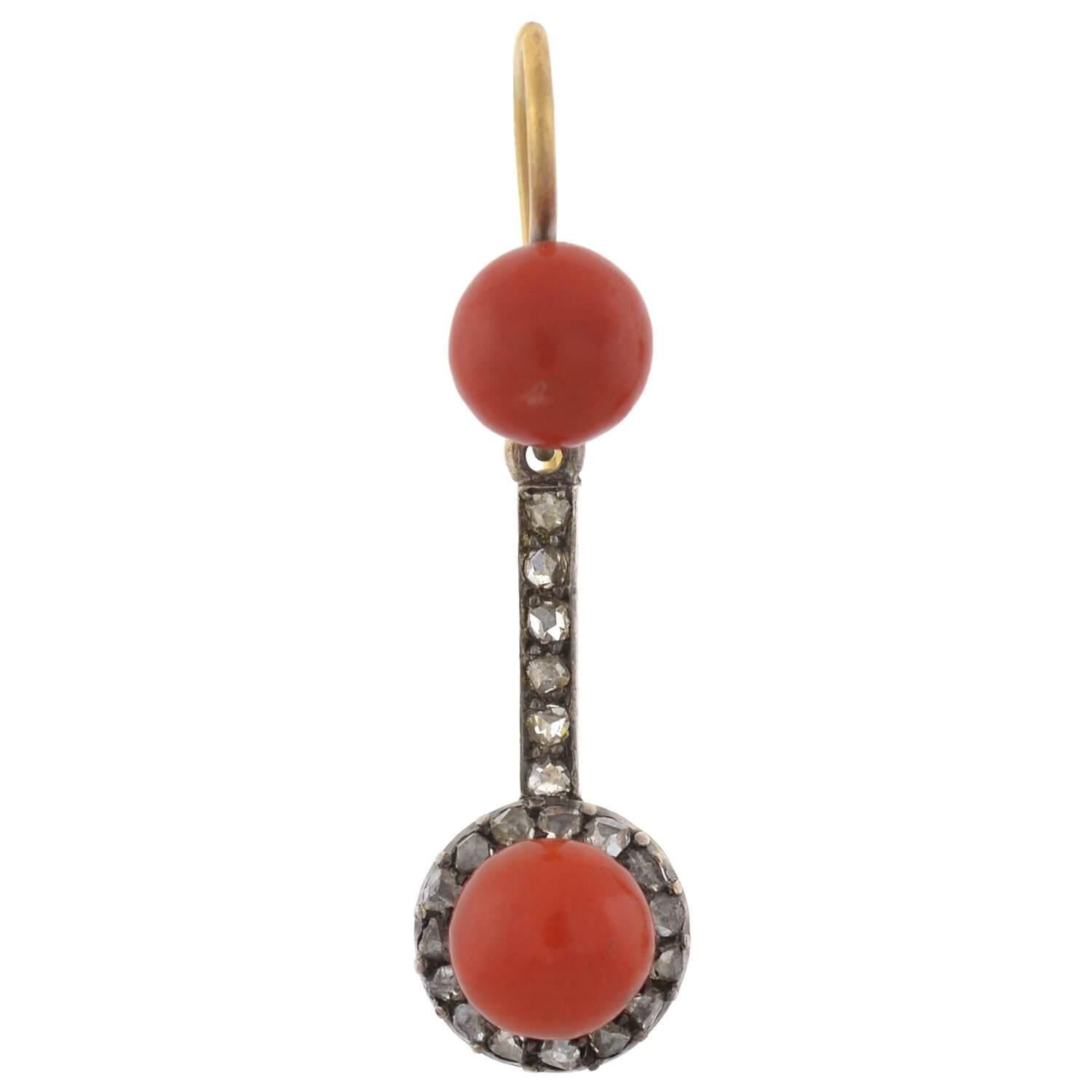 A stunning pair of coral and diamond earrings from the Victorian (ca1880) era! These beautiful dangling earrings are crafted in 15kt gold and topped in sterling silver. Each earring displays two natural coral cabochons, which have a deep salmon