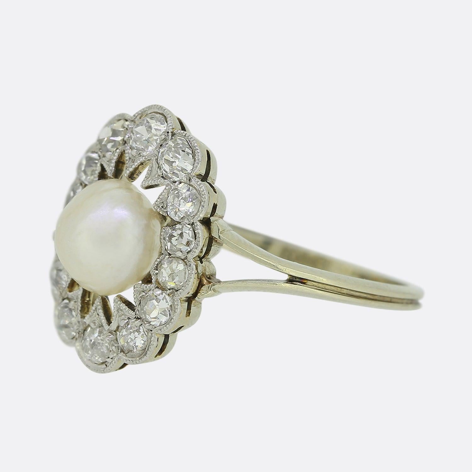 This is a superb 18ct gold pearl and diamond cluster ring. Set upon a platinum head, the central natural pearl possesses a wonderful lustre whilst the encompassing stones which circulate the outer edge are bright white sparkling old cut diamonds.