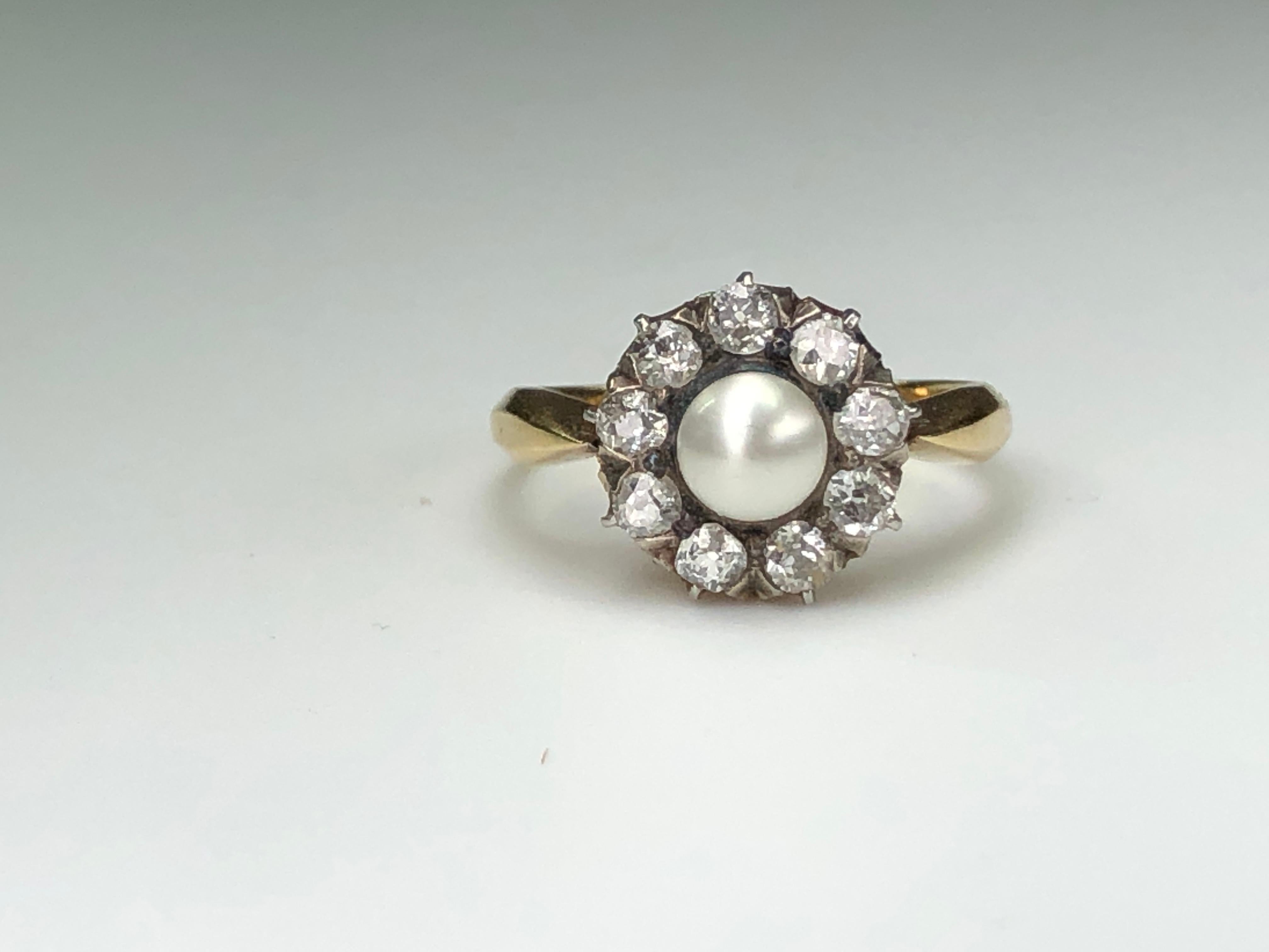 A natural pearl and diamond cluster ring, the central bouton natural pearl surrounded by nine old brilliant-cut diamonds, estimated to weigh a total of 0.9 carats, set in 18K gold mount with knife edge shank.  Circa 1890.

It is currently a size L