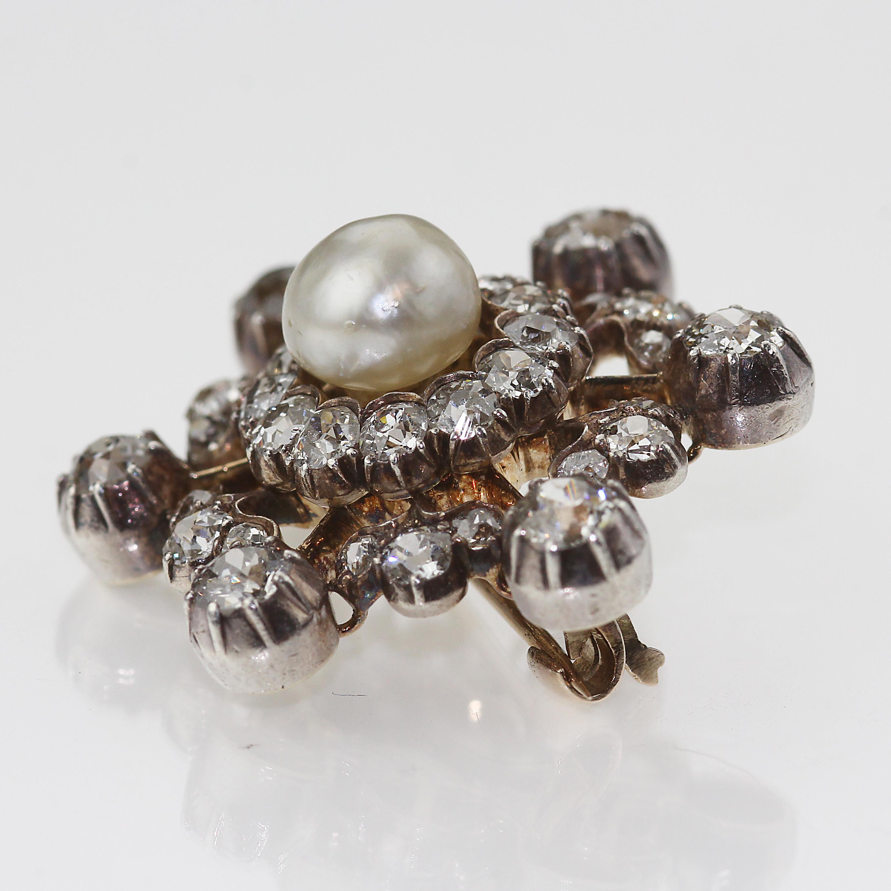 Victorian Natural Pearl and Diamond Snowflake brooch set in gold and silver.
Resembling an ever so delicate snowflake is this intricate brooch. It’s an antique Victorian stunner full of diamonds all formatted around a natural pearl, all on a gold