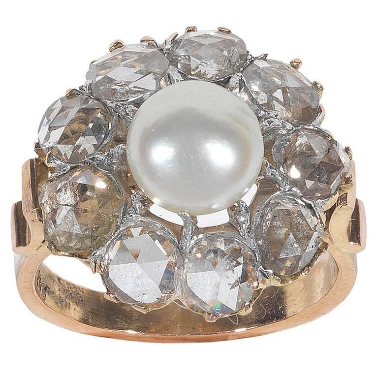 Centré par une perle sertie à griffes de 7 mm de diamètre, encadré par 9 diamants taille rose pesant approximativement 2.25 cts, à un sculpté  galerie et cerceau uni.
Monté en or, diamètre du sommet 17 mm.
Poids : 6.6 gr
Taille du doigt : 7