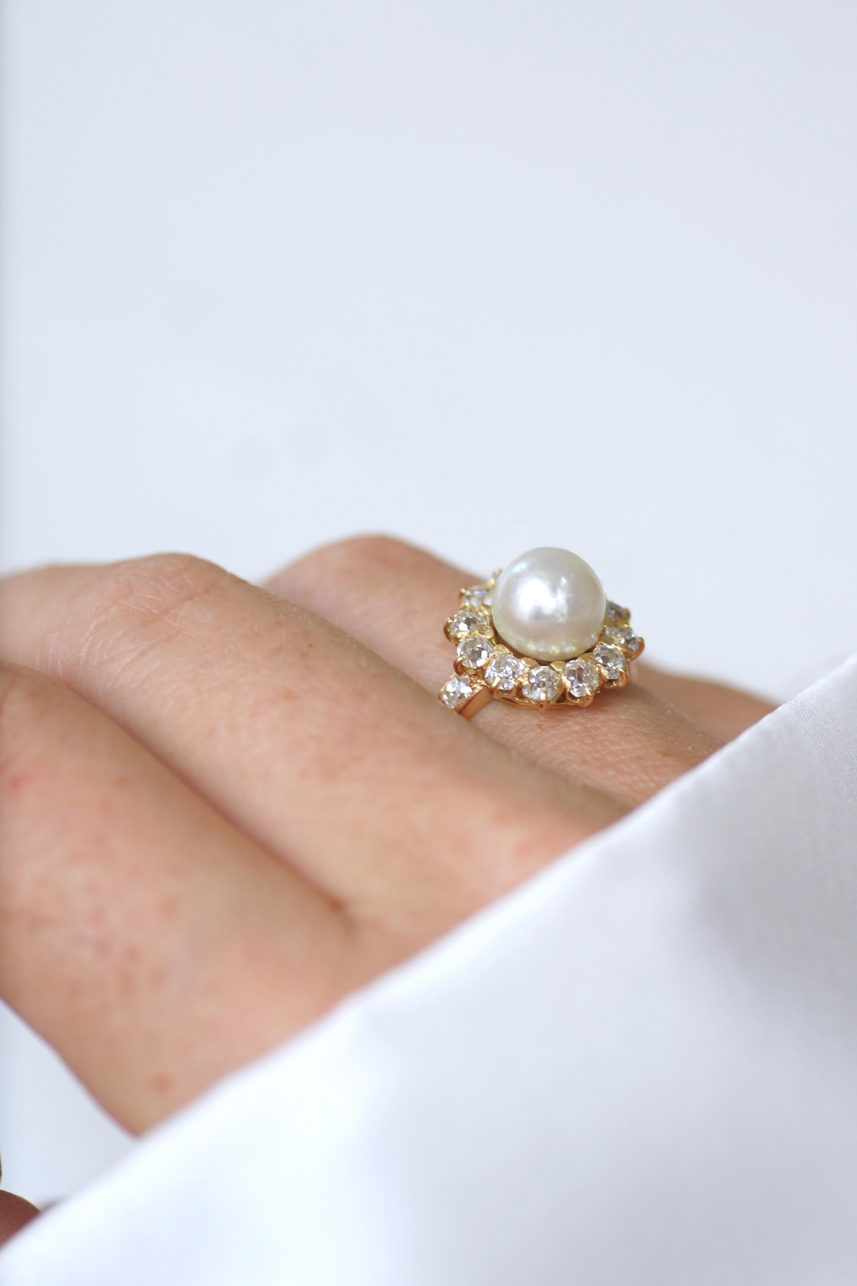Antiker Verlobungsring aus 18 Kt. Gelbgold, in der Mitte mit einer knopfförmigen Naturperle (Durchmesser: ca. 8,2 mm), umgeben von Diamanten mit altem Schliff (geschätzte Farbe H/I, geschätzte Reinheit VS bis SI).

Das Gesamtgewicht der Diamanten