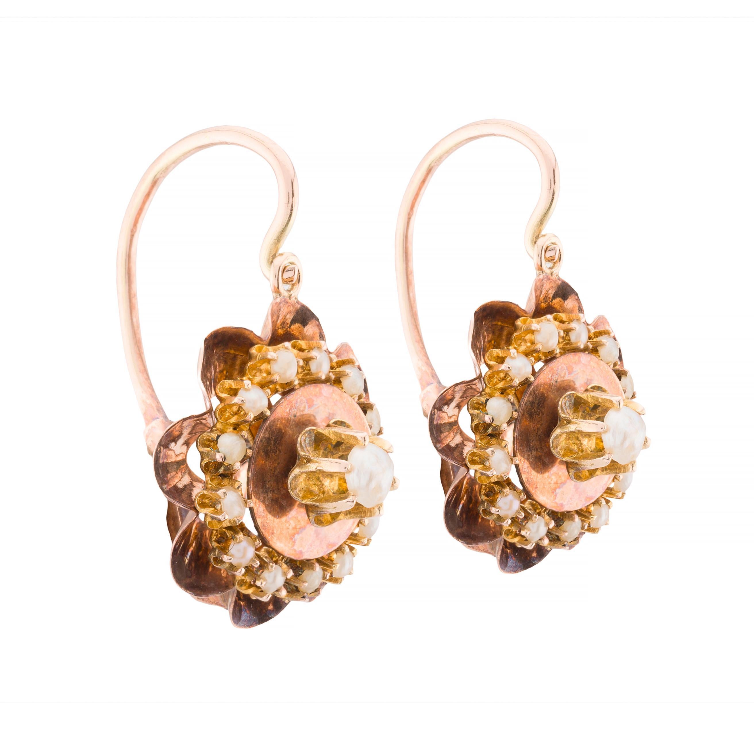 Aston Estate Jewelry Presents:

Victorian earrings crafted in 14k yellow gold. Each earring features a floral design with a central natural pearl, surrounded by smaller natural white pearls. The intricate gold petals add a touch of elegance to the