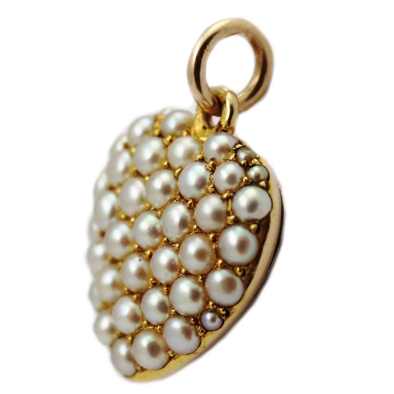 A Victorian natural pearl locket pendant, designed as a heart inset with seed pearls. The reverse cover opens out to allow you to insert memorable items or photos. The simple, evocative shape design celebrates the spirit of love. Set in 15k gold. 