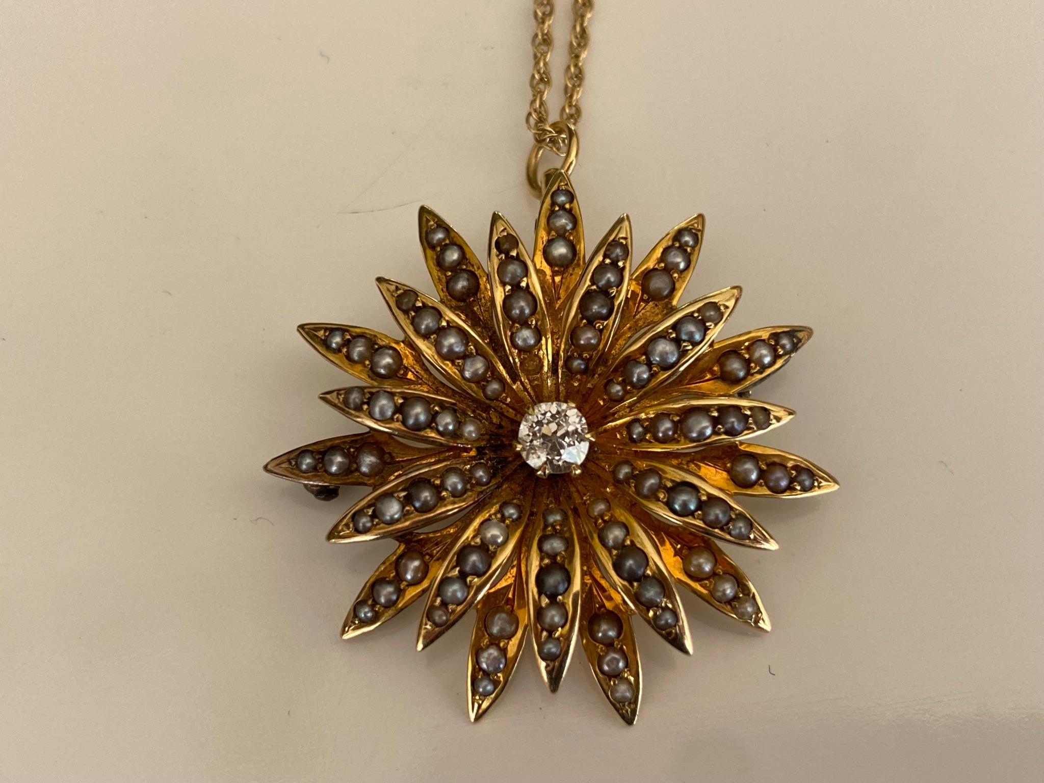Crafted in the late nineteenth century from 14kt yellow gold, this classic late-Victorian era pendant necklace is designed around an Old Mine cut diamond center stone totaling approximately 0.25 carats and accented with natural seed pearls radiating