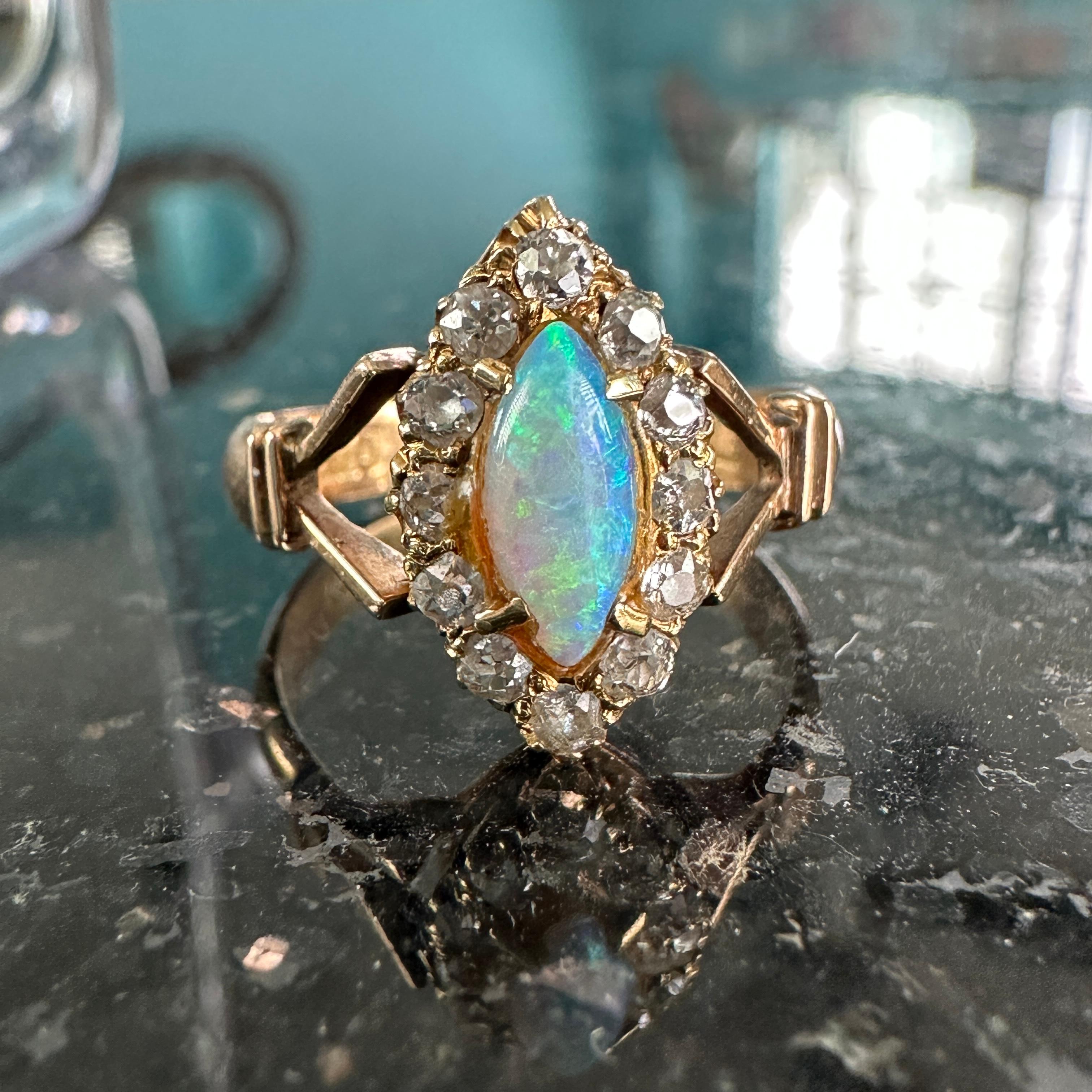 Details:
Fabulous Victorian Navette opal and diamond ring set in 18K subtle rose gold. The band has fantastic detailing, and the diamonds are lovely rose cuts. The full spectrum opal measures 8.8mm x 4mm, and has deep blues, greens, pinks and