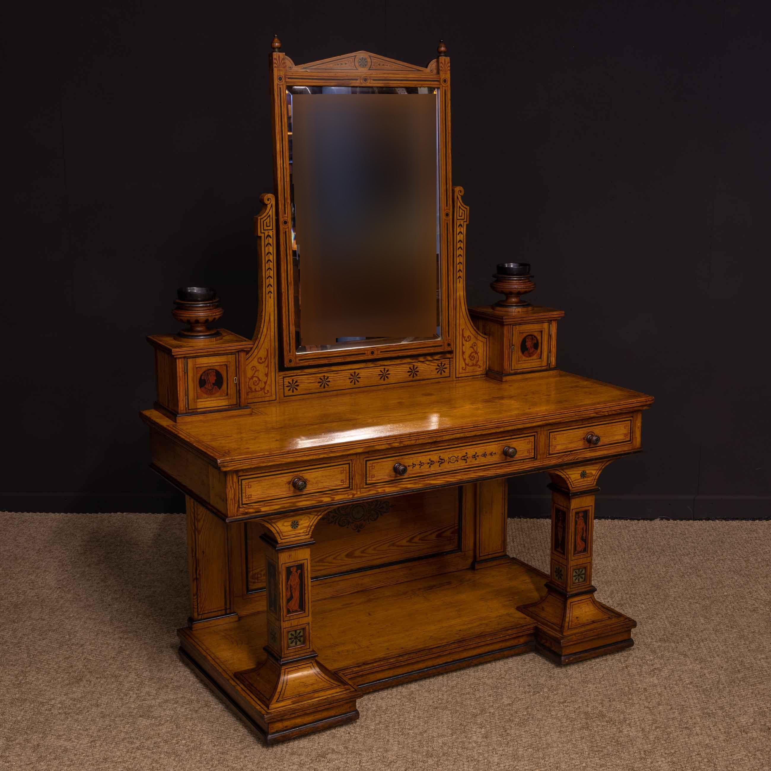 A Victorian pitch pine dressing table in a very unusual neoclassical design. Hand painted throughout in red and black lining and various foliage and geometric designs. The supports have hand painted classical portraits and urns. The drawer knobs