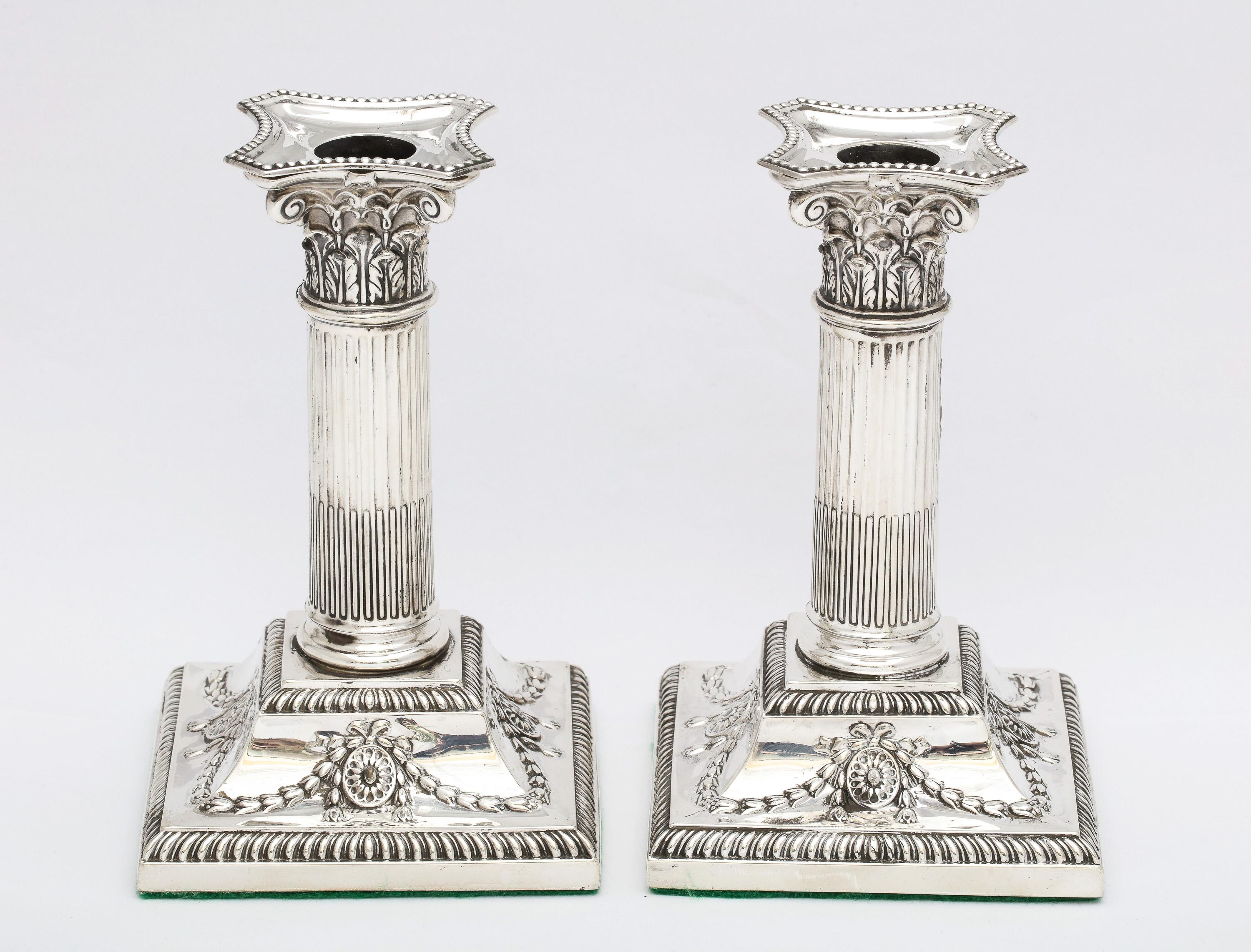 Beautiful pair of Victorian Period, neoclassical-style, sterling silver Corinthian column candlesticks, made in the city of Sheffield, England, year-hallmarked for 1898, Hawksworth, Eyre and Co., Ltd.- makers. Base of each candlestick is decorated