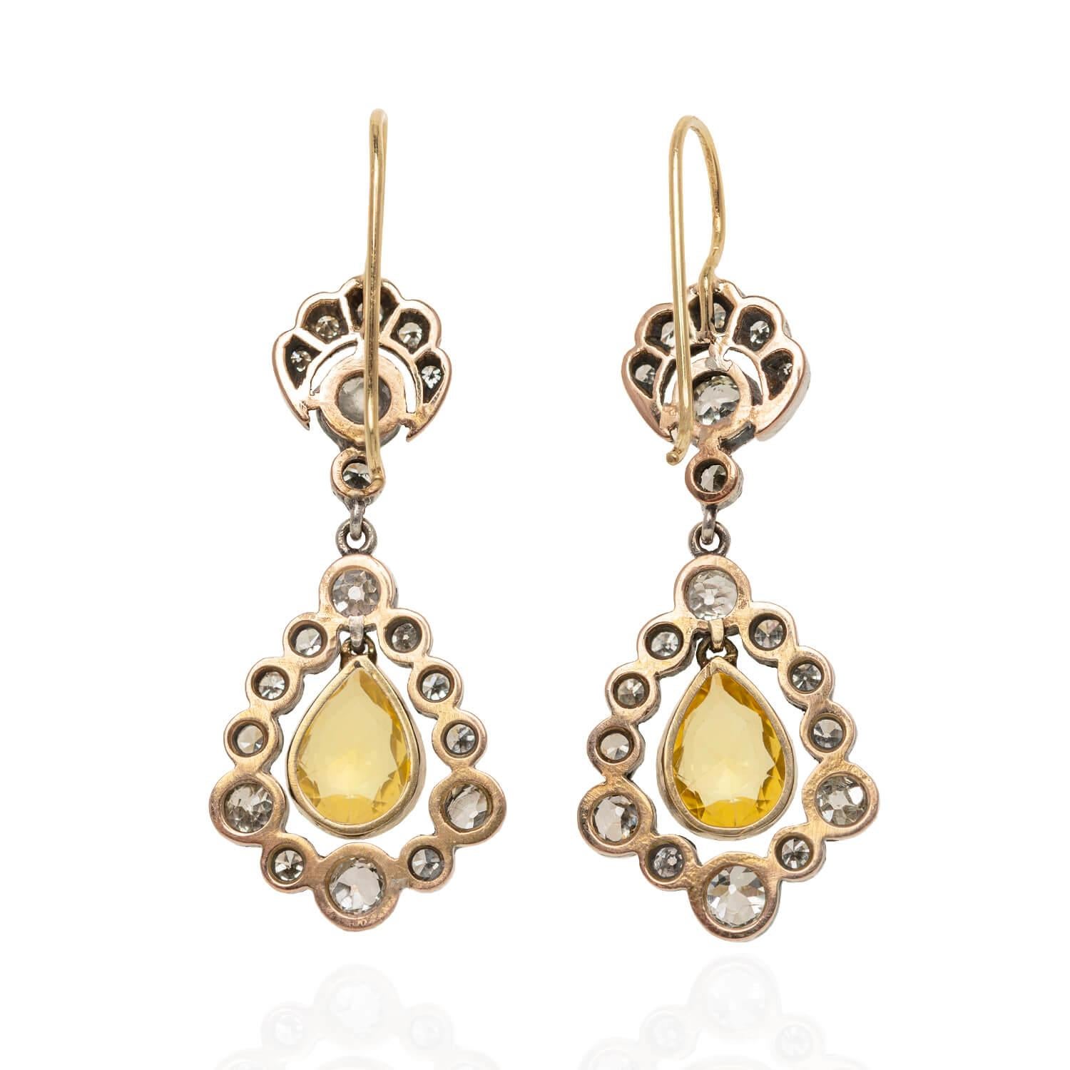 A stunning pair of earrings from the Victorian (ca1880s) era! Crafted in 18kt yellow gold and topped in sterling silver, these incredible earrings begin with an ornate surmount. Five graduated Single Cut diamonds are in a tiara-like frame atop an
