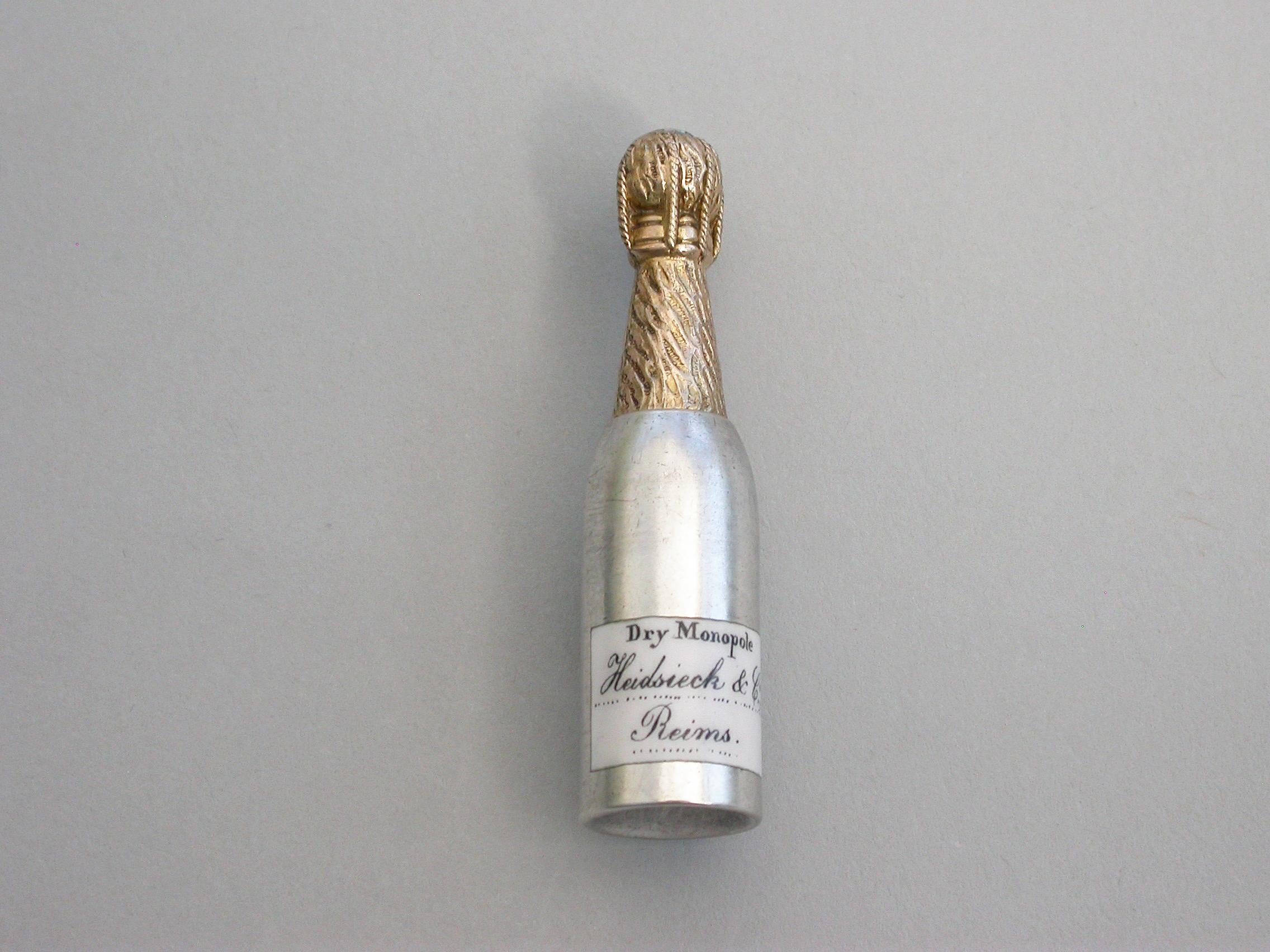 A rare Victorian Novelty silver Propelling Pencil modeled as a champagne bottle, with gilded top to imitate the foil and applied black and white enameled label for 'Heidssieck & Co, Reims'.

Unmarked, but probably by Sampson Mordan & Co, circa