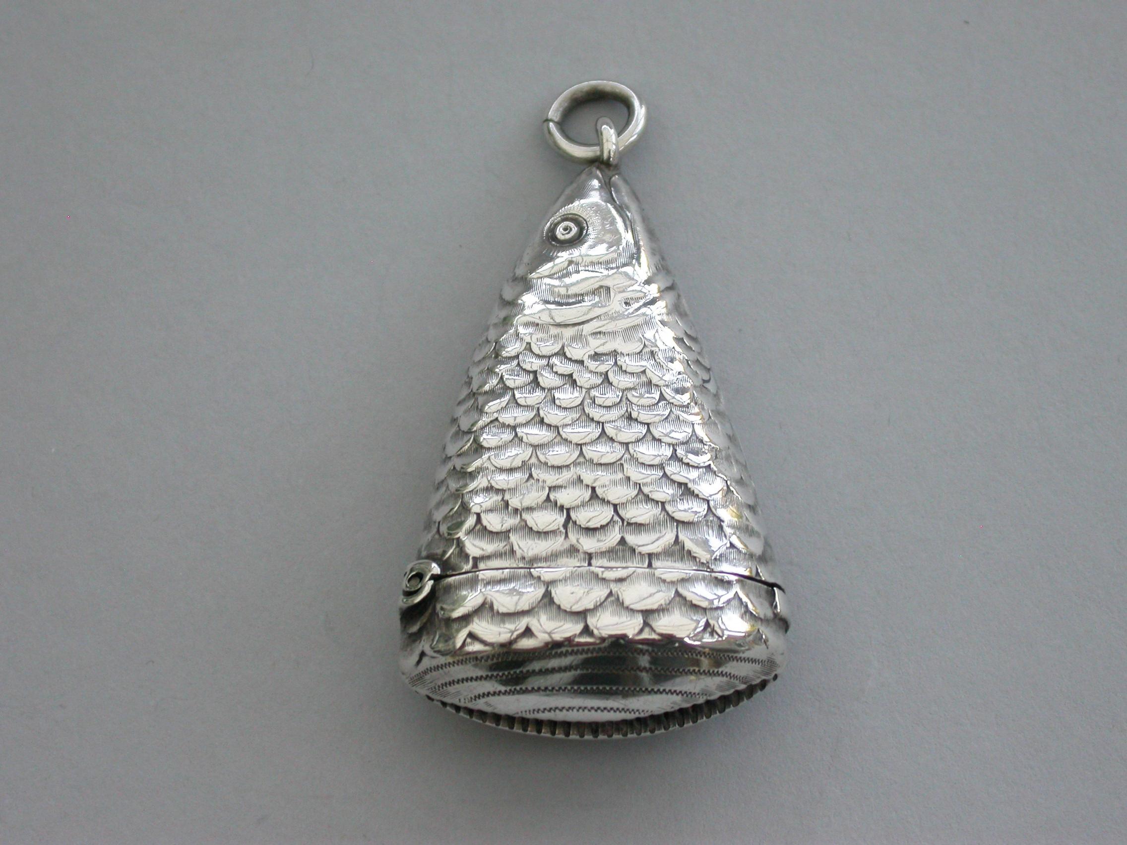 An extremely rare Victorian novelty silver Vesta case made in the form of a fish's head with realistically cast scales, attached suspension ring a sprung hinged lid.

By William Oliver, Birmingham, 1892.

Also stamped with registered design
