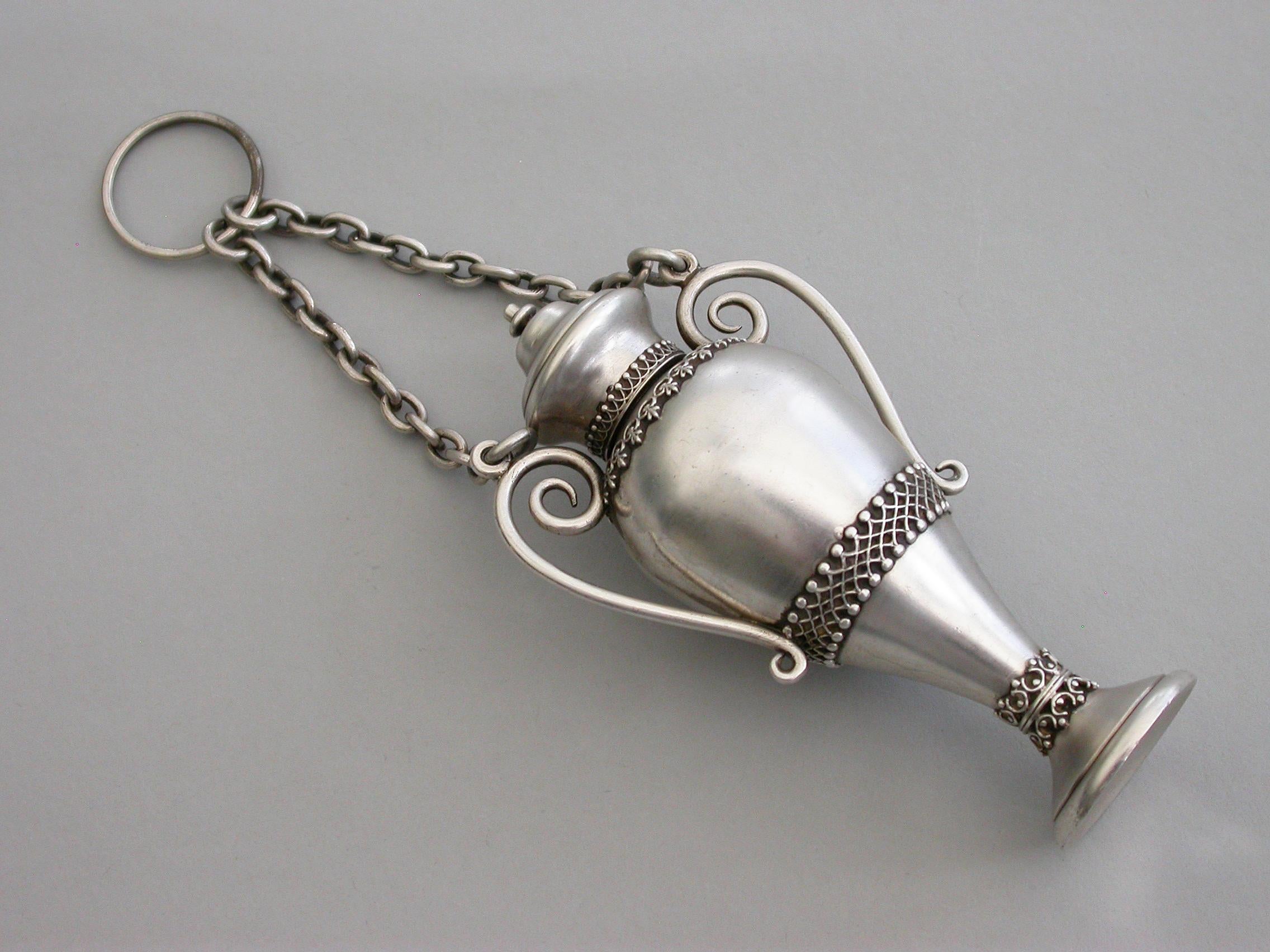 A good quality Victorian novelty silver scent bottle made in the form of a twin-handled vase with attached suspension ring and chains. Applied with raised bands of pierced interlocking decoration. Screw-off cover.

By Sampson Mordan & Co, London,