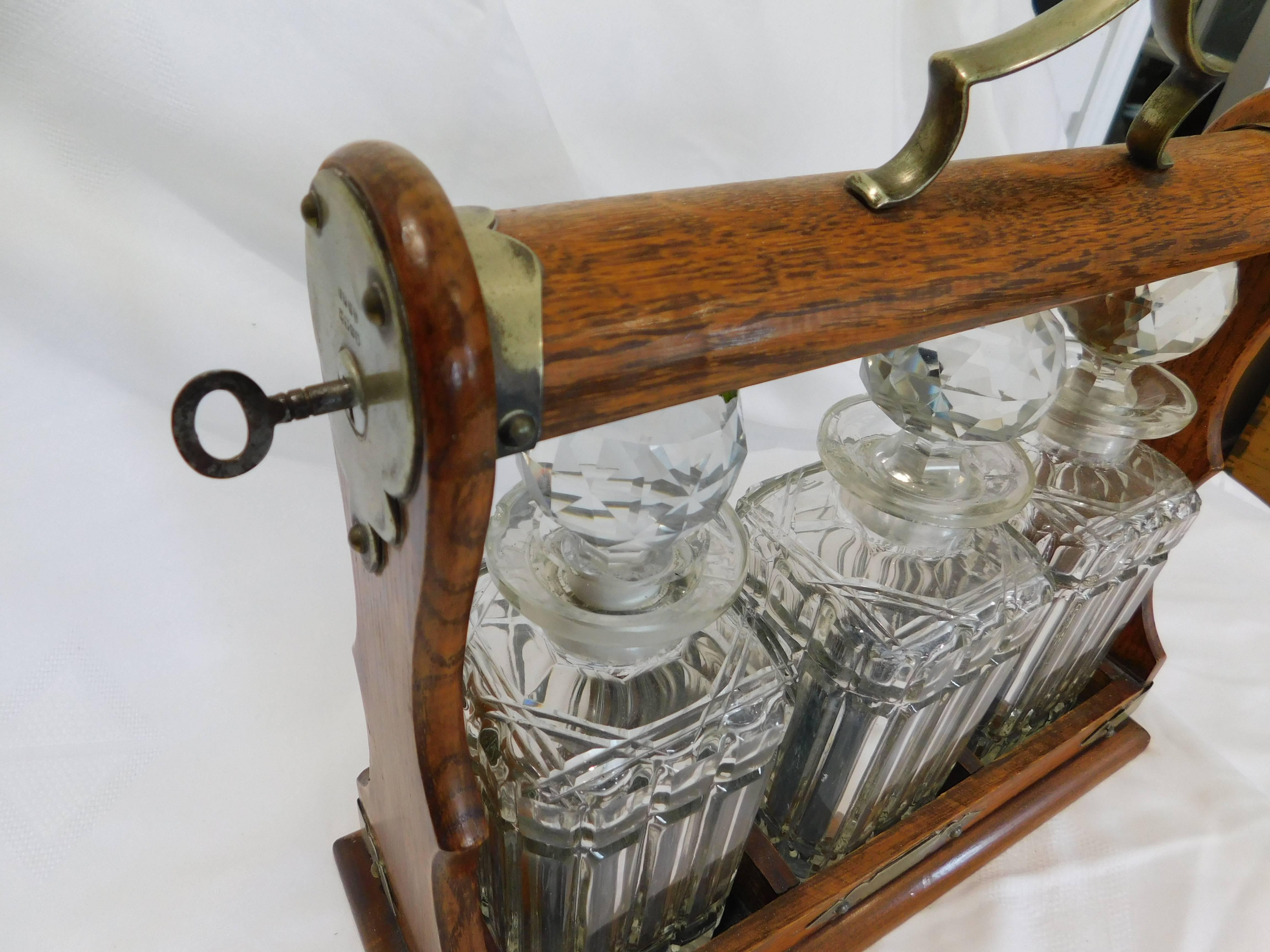 Tántalo victoriano de roble y metal plateado con decantadores de cristal Inglés en venta
