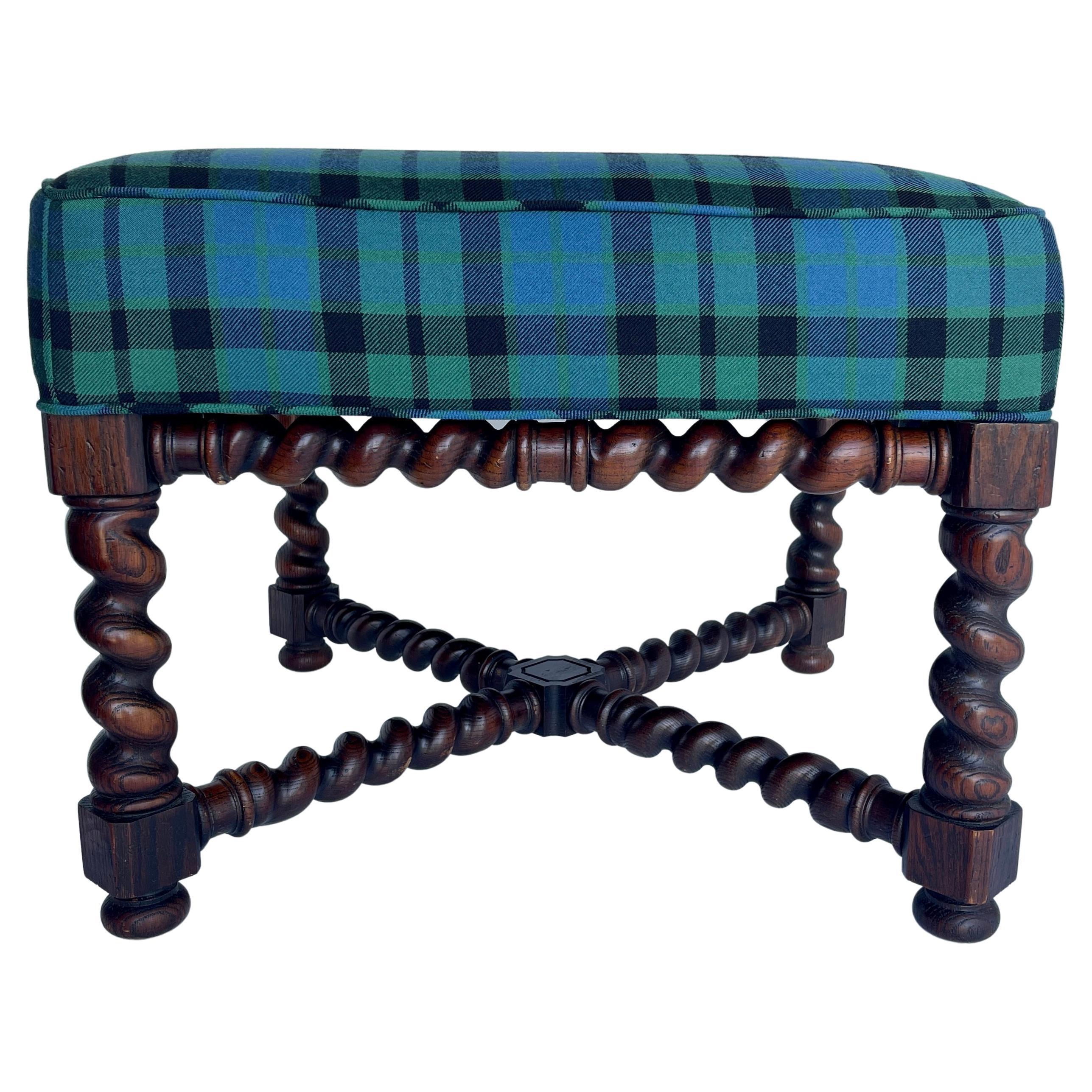 Victorian oak barley twist ottoman in blue and green tartan plaid upholstery, circa 1920's. 
This newly upholstered ottoman is bold and beautiful. The barley twist design frame is accentuated with cross bars that bear the same turned wood as the