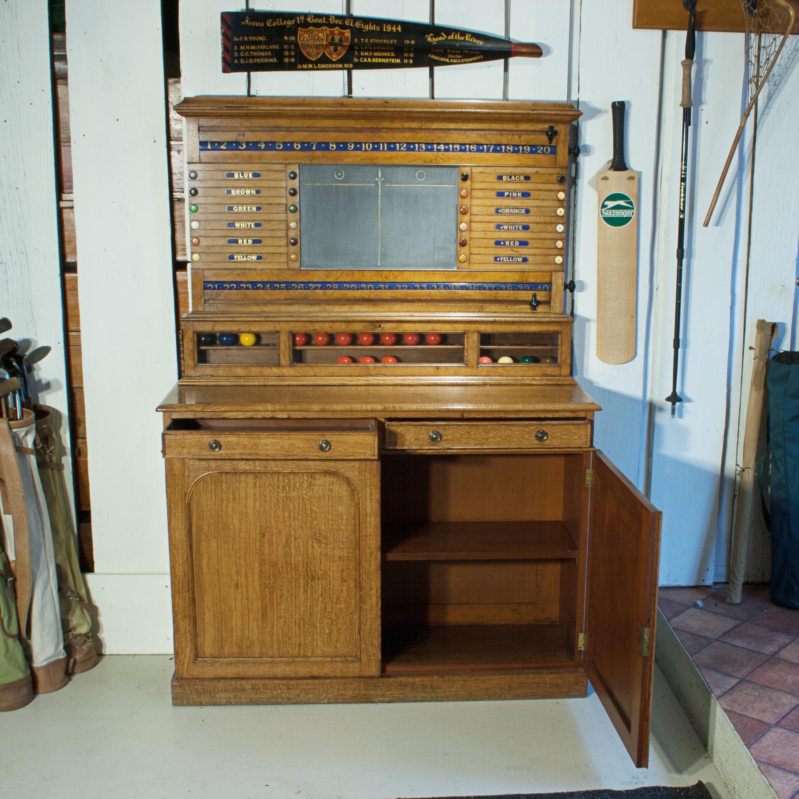 Snooker, Billiards & Life pool scoreboard attributed to Thurston & Co.
A nice combined Victorian billiards and life pool scoreboard made of light oak. The billiard scorer sits upon a lockable ball cabinet that can house 32 balls, which then sits