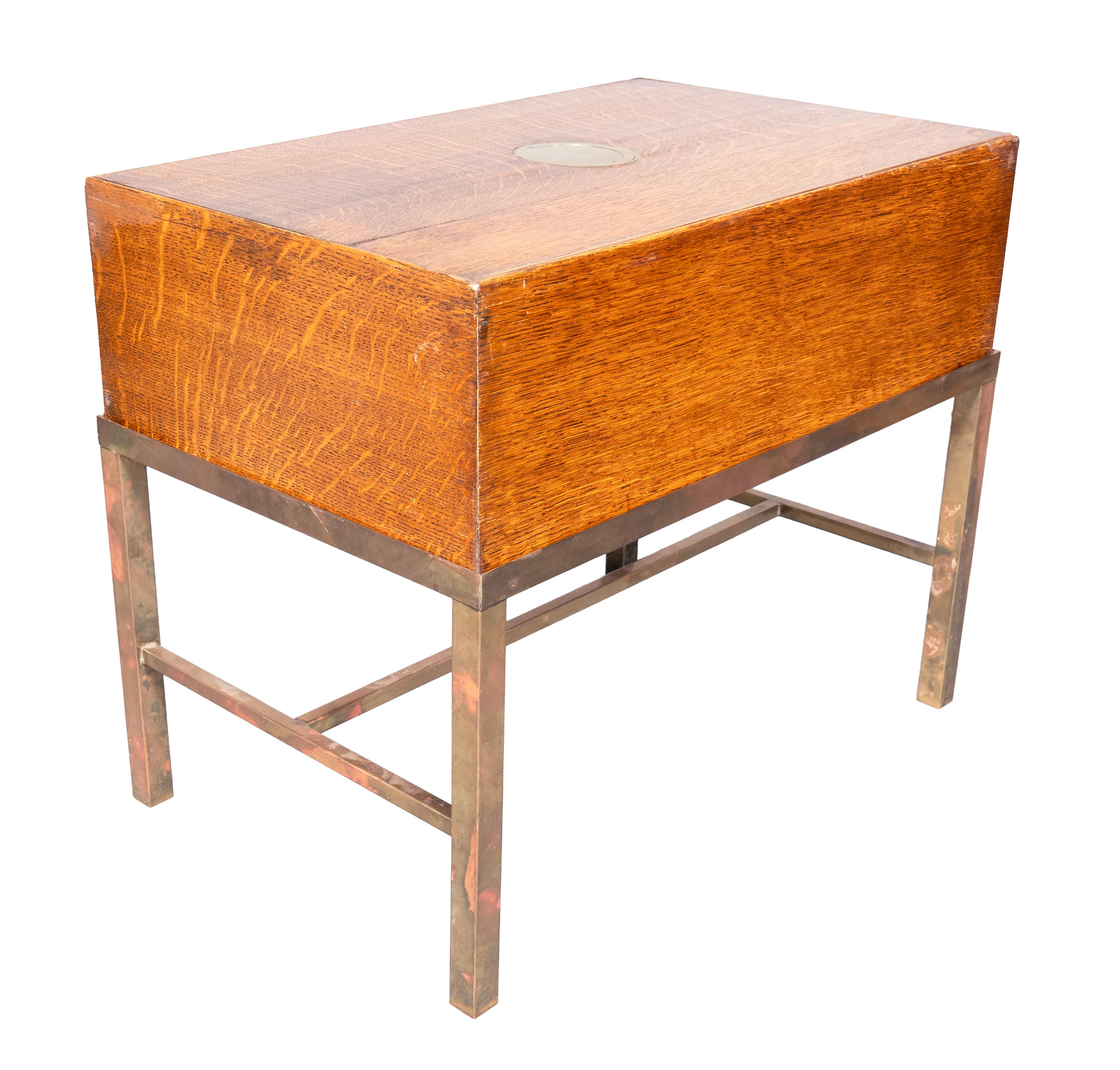 Piano e lati rettangolari sollevabili con maniglia in ottone incassata. Cassa conforme con base in ottone successiva con gambe quadrate e barella.