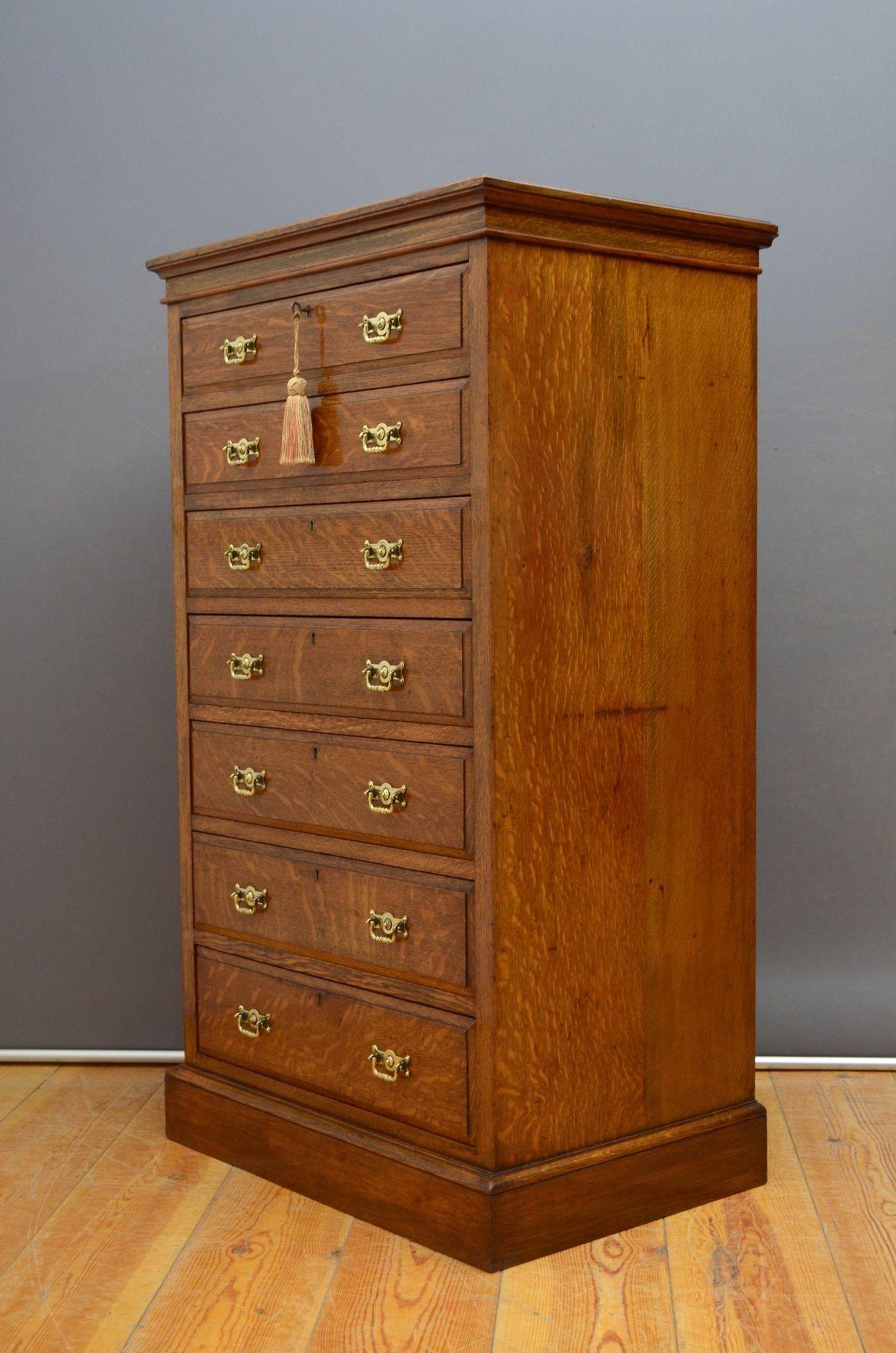 R036 Fine quality Victorian oak Wellington chest by Maple and Co, having oversailing top with moulded edge above seven mahogany lined, fielded and graduated drawers all fitted with original brass handles, working locks and a key, standing on plinth