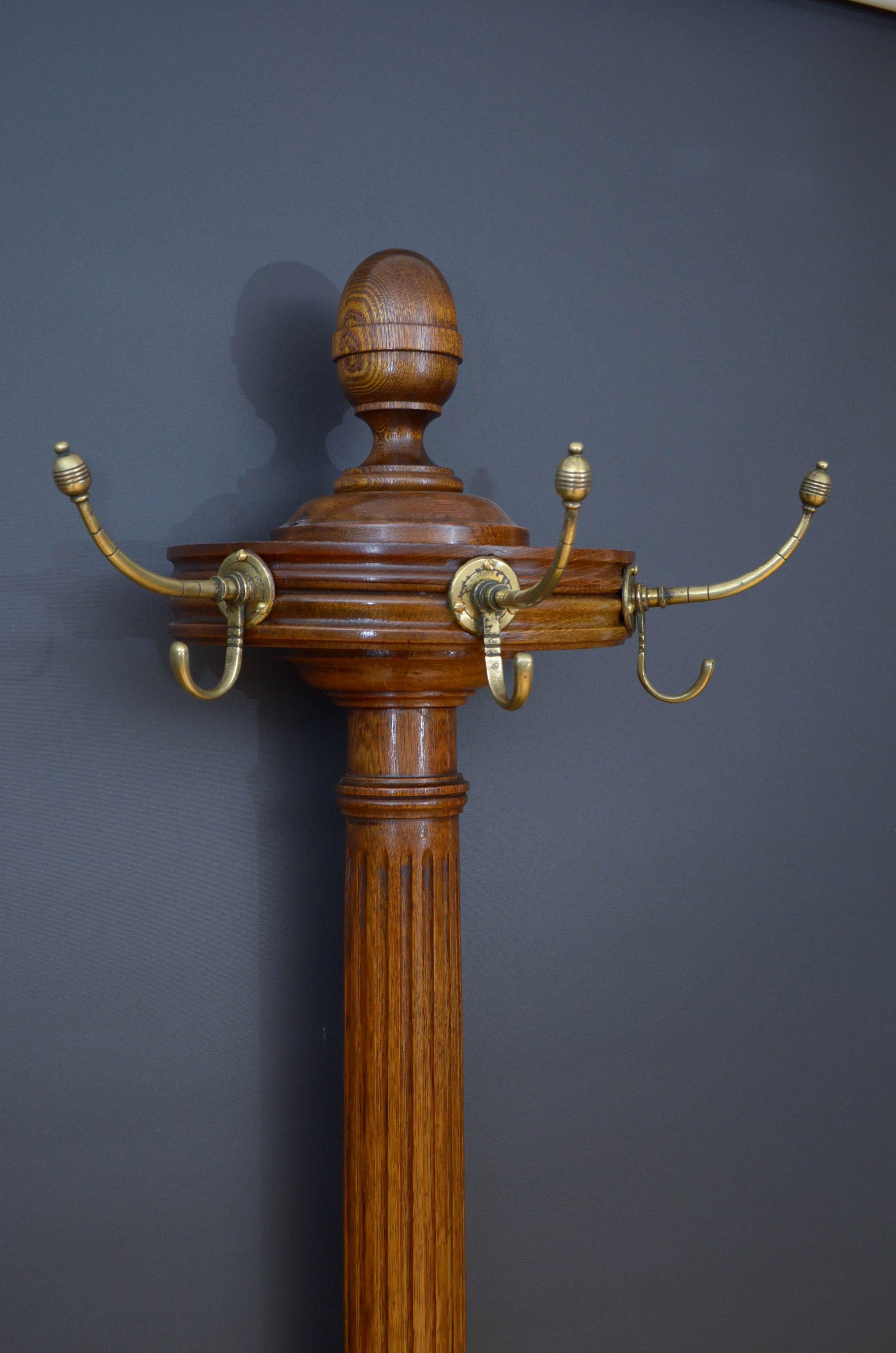 Sn5155 Stylish Victorian hall stand in oak, having three original brass hooks surmounted with acorn finial raised on turned, reeded upright terminating in shaped base with double umbrella holder and two removable drip trays, all standing on moulded