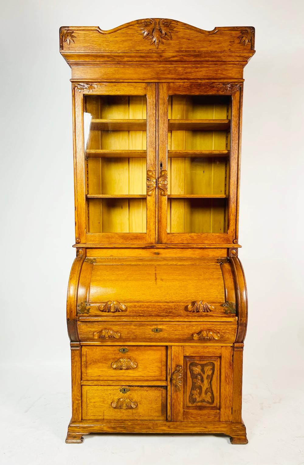 Very nice Eastlake Victorian oak cylinder desk with a bookcase top section. The drawers and door fronts have a beutiful carved details carved as handles. 

Measurements:
91 inches high x 37.50 inches wide x 21.50 inches deep.
The top portion is