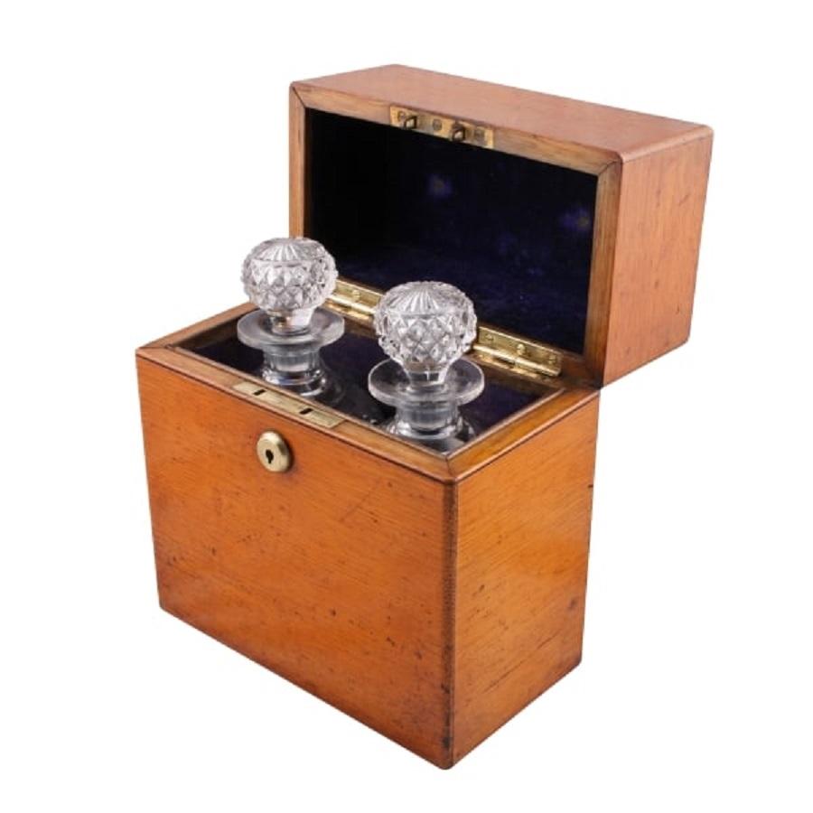 A 19th century Victorian oak decanter box.

The box has a hinged lid, is velvet lined inside and holds two original matching spirit decanters.

The decanters are square based with chamfered corners and the upper part of the body is hobnail cut