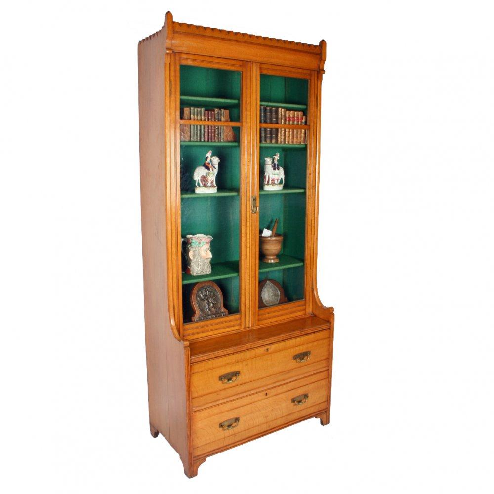 A late 19th century Victorian oak bookcase made in one piece.

The bookcase has two glazed doors over two long drawers with brass plate handles.

The bookcase is light in colour and is decorated with a reeded line to the drawers and door fronts