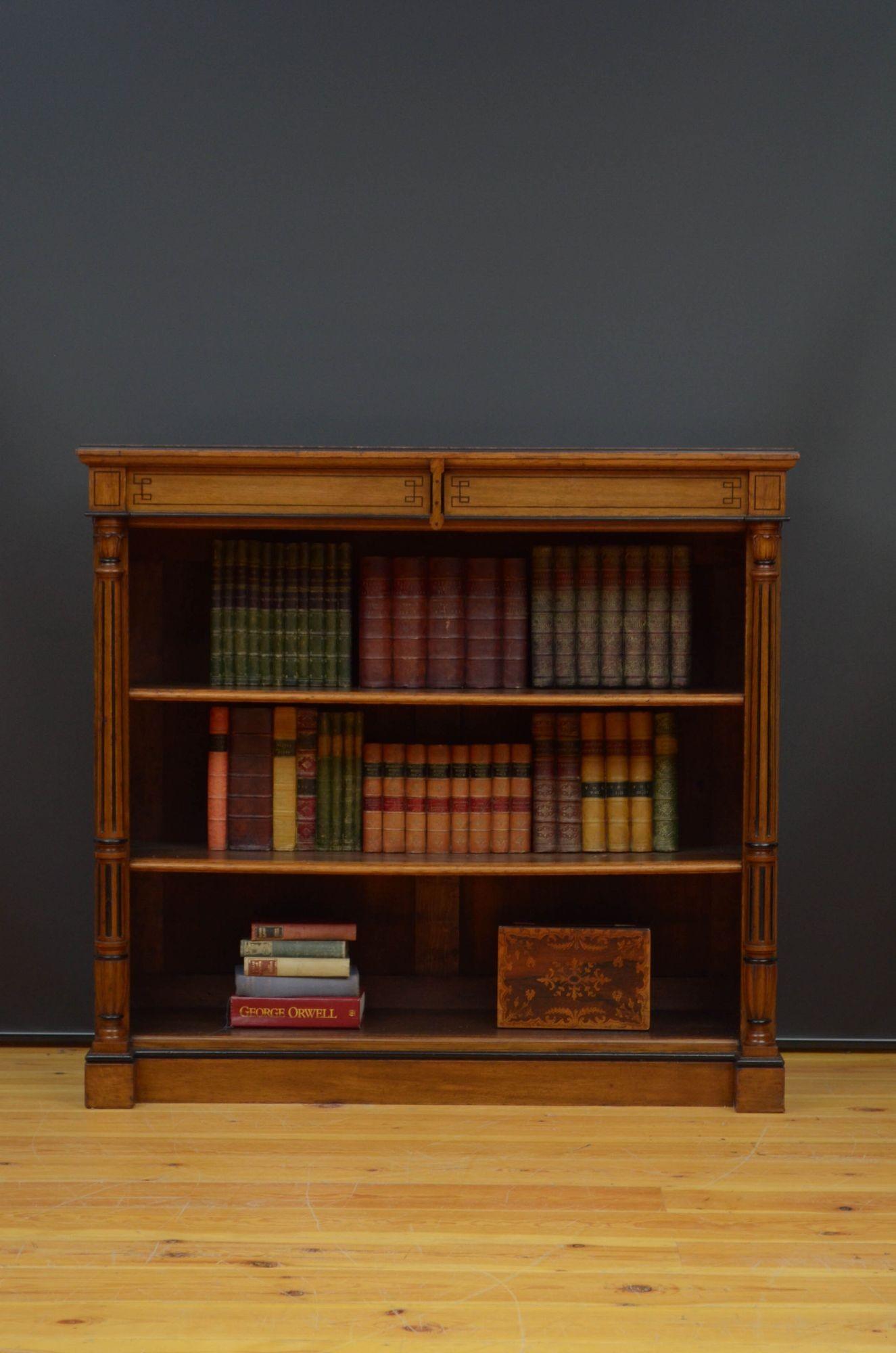 Sn5427 Stylish Victorian open bookcase in oak, having oversailing top with moulded and ebonised edge above two string inlaid frieze drawers and tow height adjustable shelves flanked by reeded columns with flower carved capitols, standing on moulded