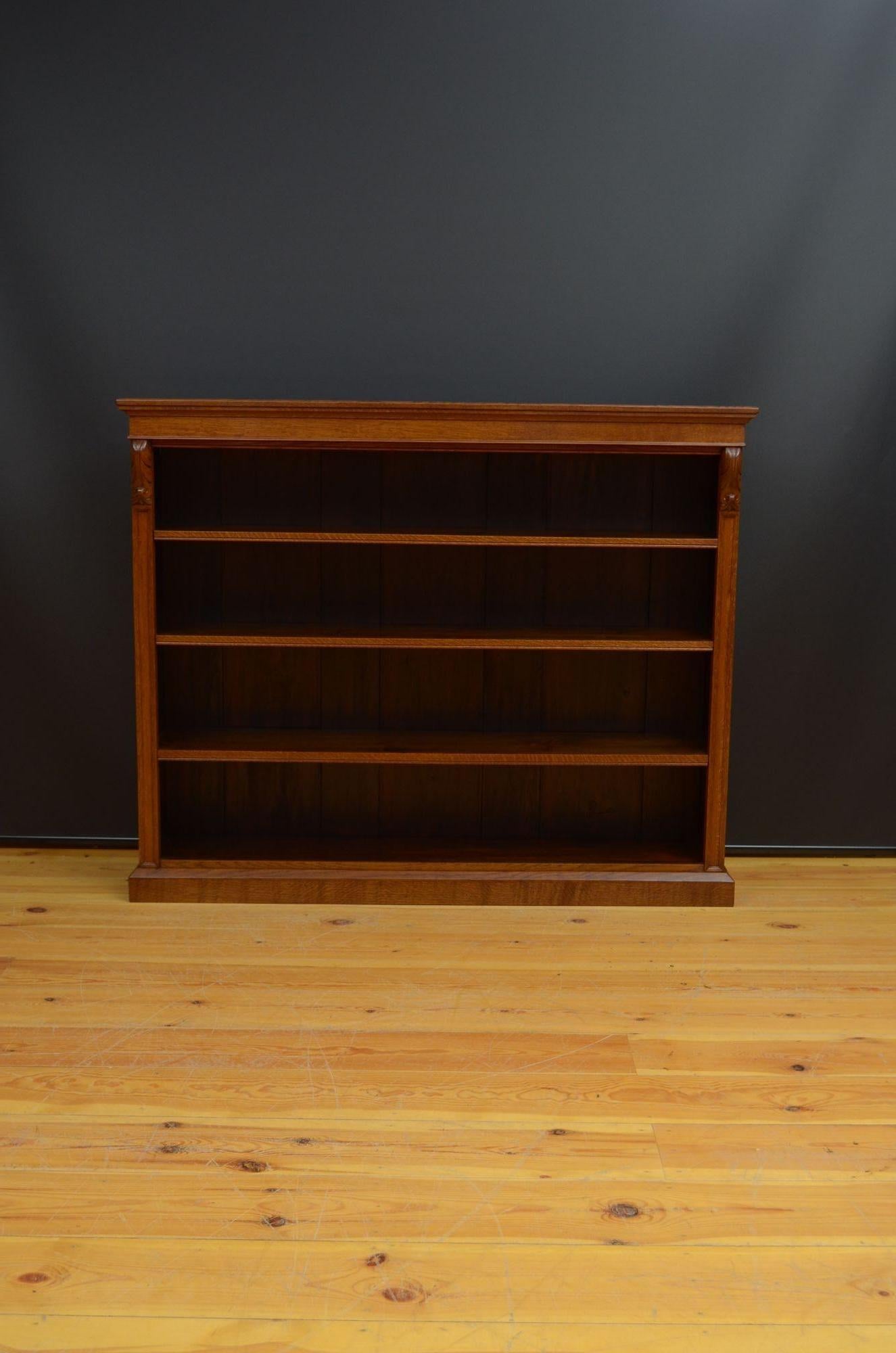 R040 Victorian oak open bookcase, having a solid oak top above shallow frieze and three height adjustable shelves flanked by moulded pilasters and fine drop carvings, all standing on a canted plinth base.
This antique bookcase is in home ready