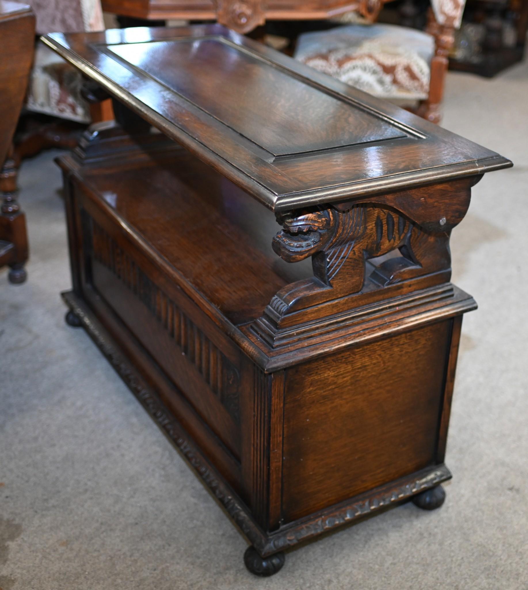 Classic mid-Victorian oak settle or monks bench
Features elaborately carved details including the unique creature handles
Has an almost Gothic look with horizontal designs to the back rest
Classic hutch / monks table as the back folds over to create