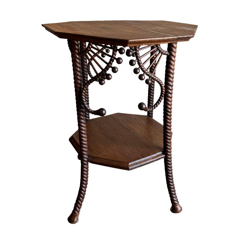 A rare antique stick and ball wood side taboret table. This accent table is created from wood and is in an octagonal shape. The piece features two tiers, making it great for displaying pieces on both the top and bottom. It has four rope-like