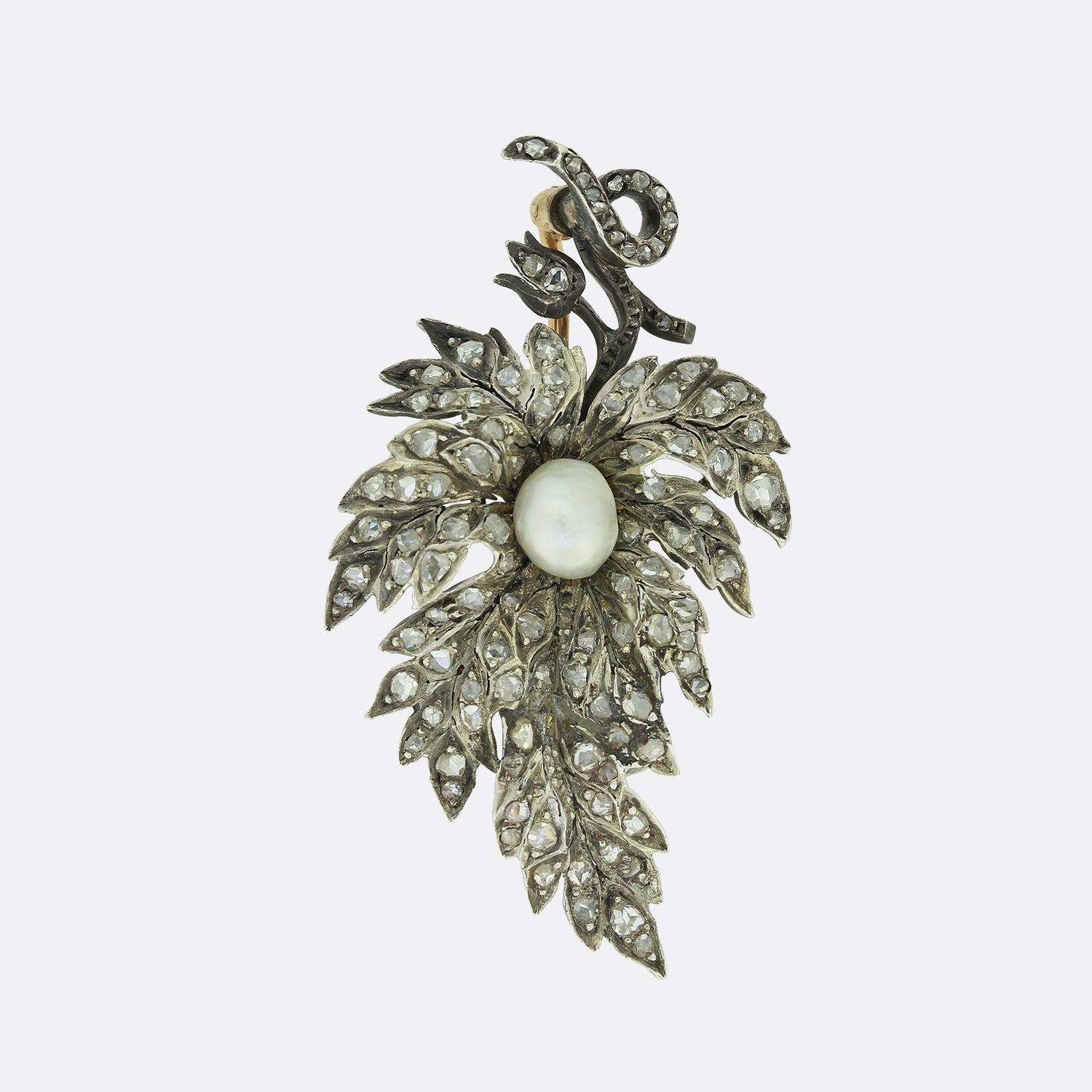 This is a truly wonderful Victorian era diamond brooch. The brooch features a large flower which has been set with an array of rose cut diamonds with a large central natural pearl. The stem and petal of the flower have also been set with more rose