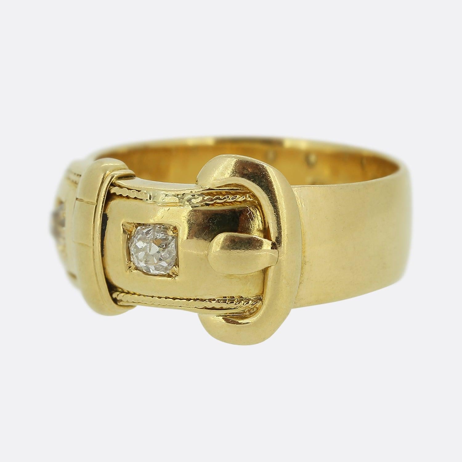Here we have an 18ct yellow gold ring from the Victorian era. This antique piece has been crafted into the shape of a belt buckle and plays host to two chunky old cut diamonds which sit claw set amidst fine milgrain detailing and an otherwise