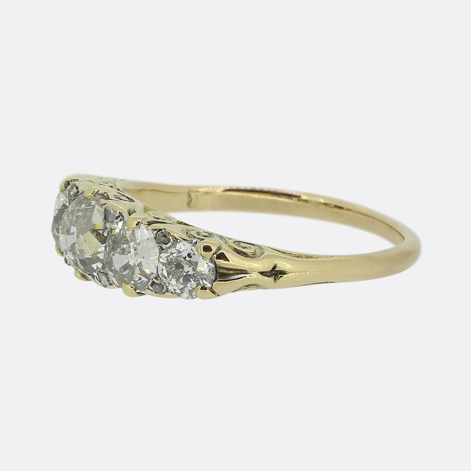 Here we have a stunning Victorian five-stone ring. This antique piece has been crafted from a warm 18ct yellow gold and features a row of five round faceted old mine cut diamonds, each exuding a captivating white brilliance. Interspersed between