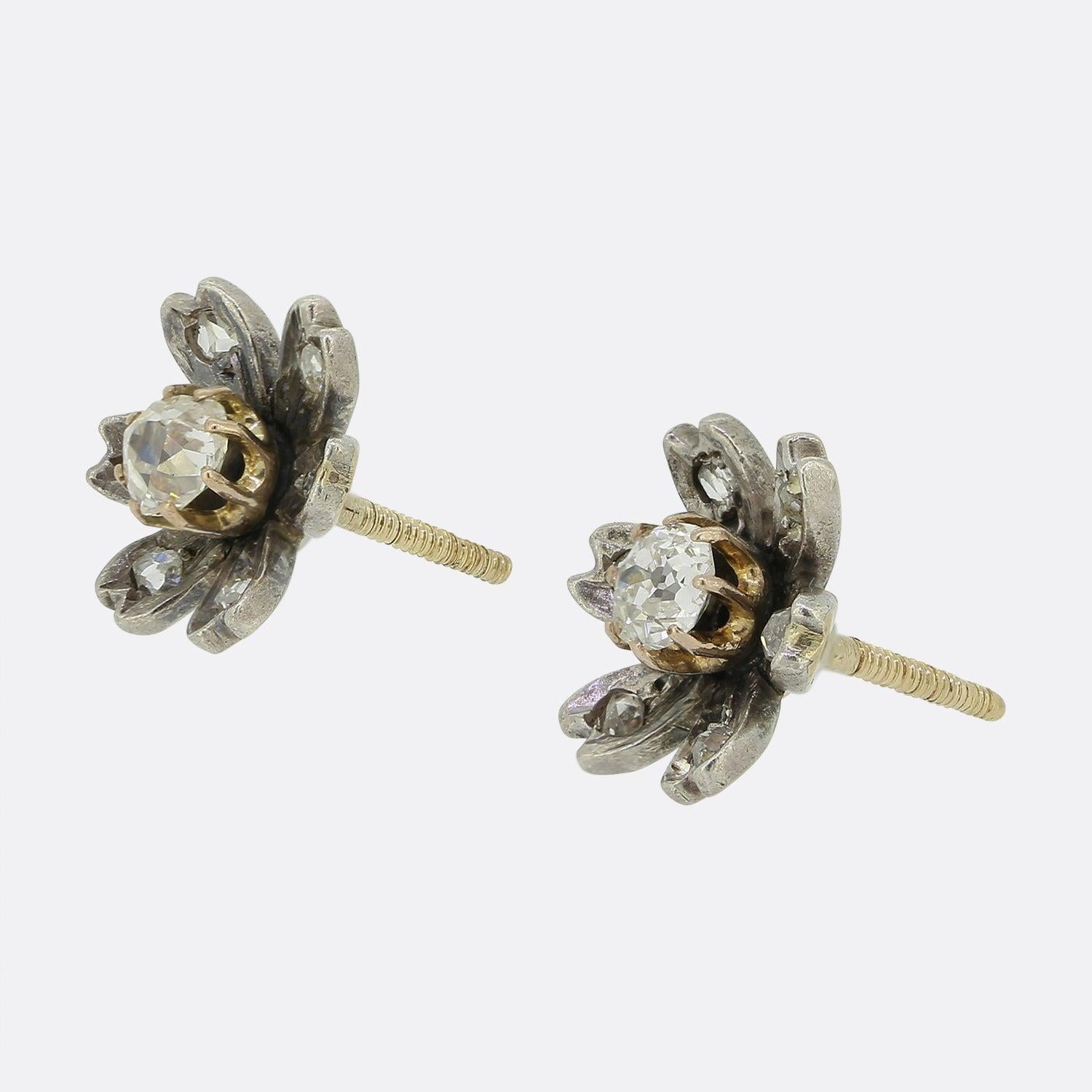 Here we have an antique pair of diamond stud earrings from the Victorian era. Each piece has been crafted from silver into the shape of a flower head with each individual petal playing host to a single rose cut diamond. A the centre of each frame we