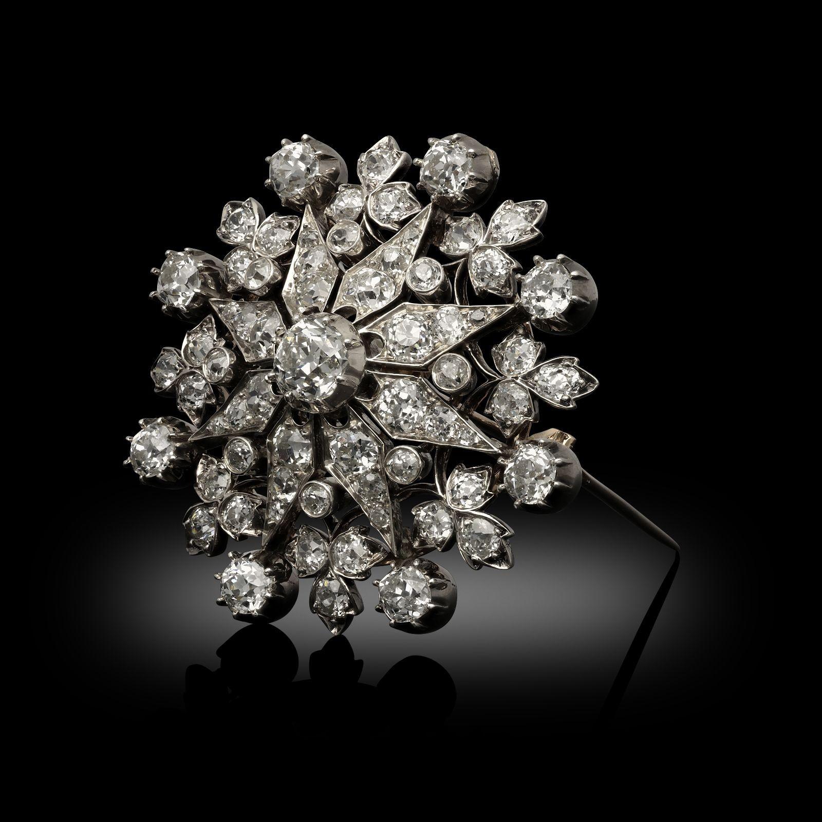 A Victorian old cut diamond 'Starburst' pendant with detachable brooch fitting, circa 1880. The pendant is set with an estimated total of 11.15ct old cut diamonds, old mine cushion cuts and old European cut diamonds all set in silver cut down