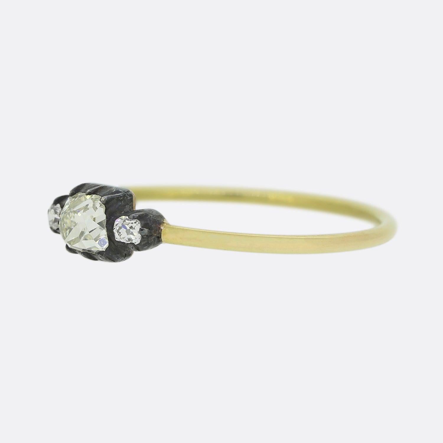 Here we have a lovely three stone diamond ring borrowing from the late Victorian style. Set upon a thin 18ct yellow gold band, the face of the piece presents a trio of old cut diamonds; each of which has been individually set in a silver cut collet