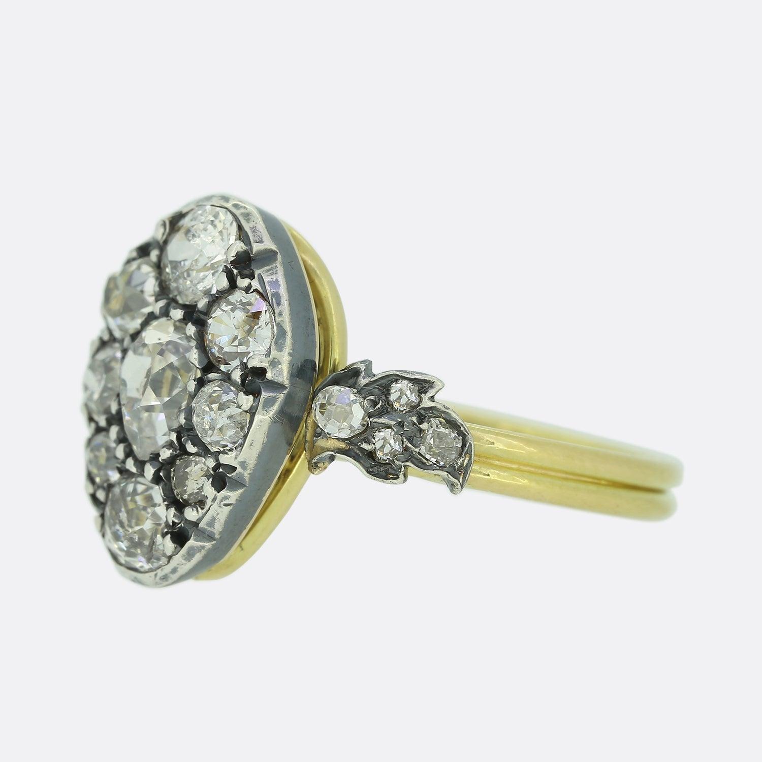 This is a beautiful, 18ct yellow gold diamond cluster ring. The ring features a central old cut pear shaped diamond and is surrounded by eight smaller old cut diamonds that vary in shape and size. The diamonds are silver set in cut down collet