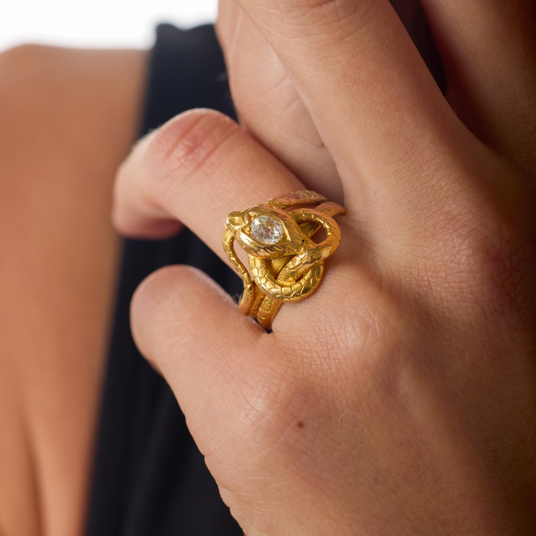 Este evocador anillo de serpiente victoriano se enrolla con gracia alrededor del dedo, coronado con un brillante diamante de talla europea antigua que aporta un fuego suave y antiguo al diseño. Su rico cuerpo de oro amarillo de 18 quilates se curva