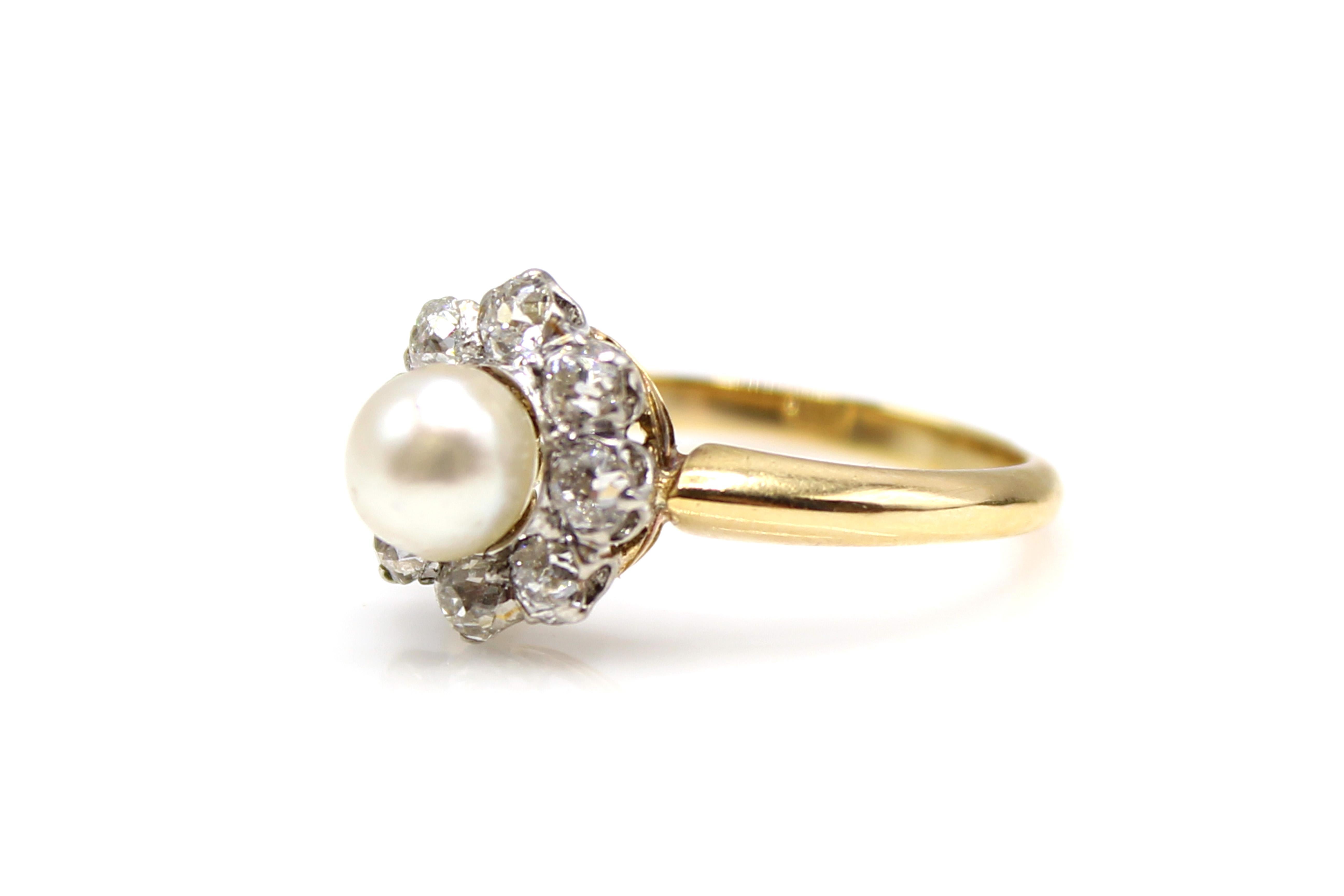 Amazingly well hand-crafted this charming Victorian ring from ca 1880 is crafted in platinum topped 18 karat yellow gold. 8 bright white and sparkly Old European cut diamonds are prong set around 1 larger 5.7 mm pearl, reminding one of a flower with